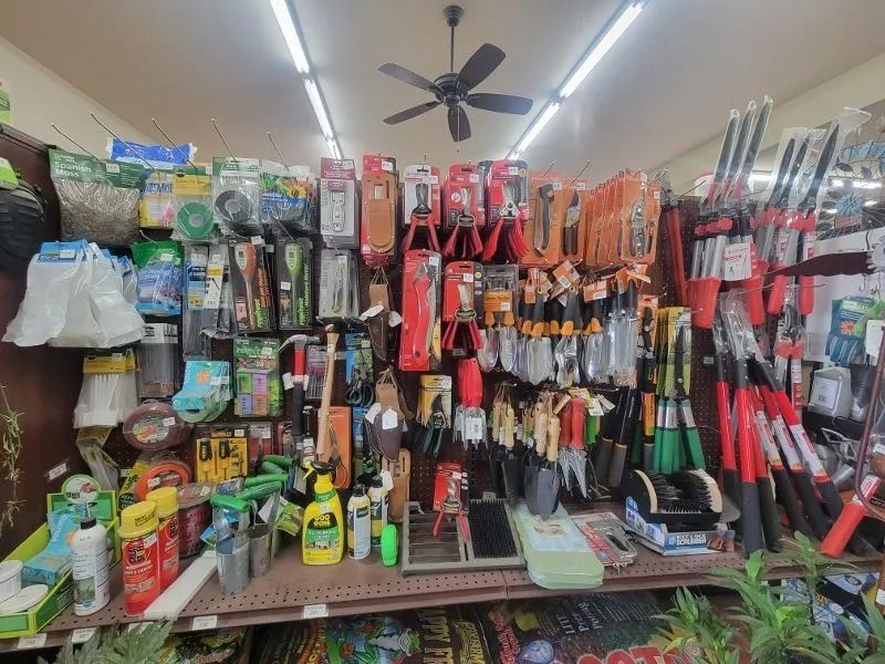 Store shelf packed with hanging tools, supplies, and household items in a small shop