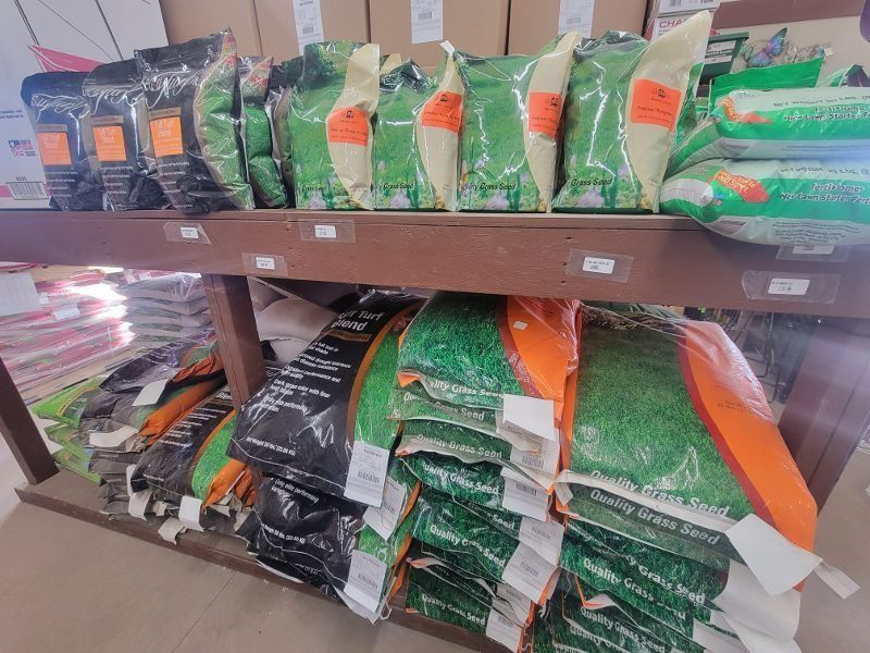 Shelves stocked with stacked bags of pet food in green, black, and orange packaging.