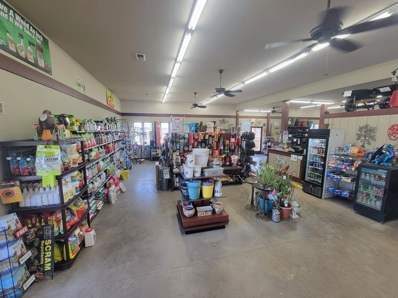 Interior of a small convenience store with aisles of snacks, drinks, and household items.