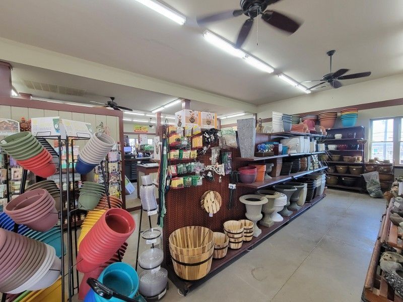 Interior of a garden supply store with shelves of baskets, pots, and home decor items