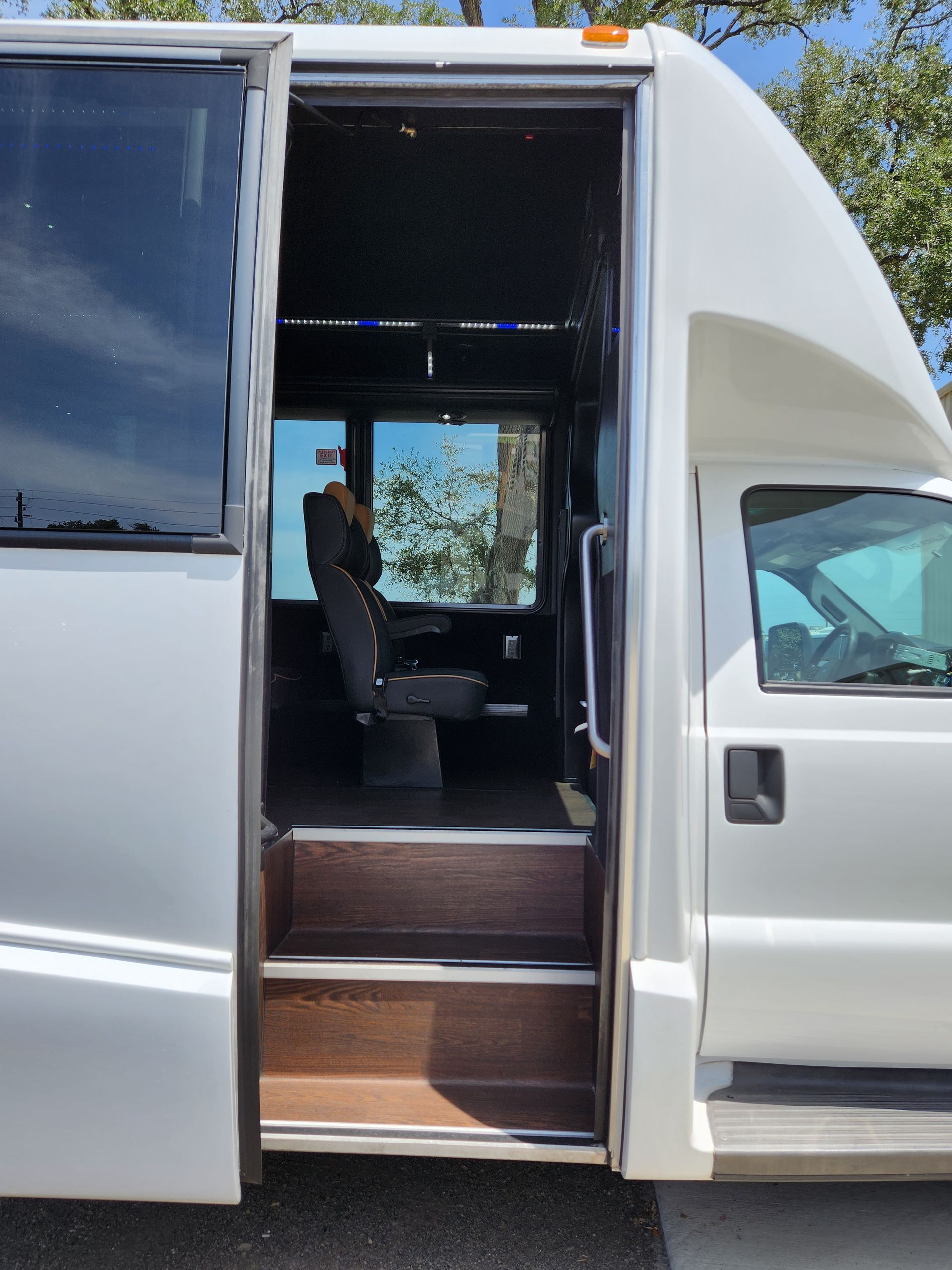 Exterior view of a white shuttle bus with open doorway