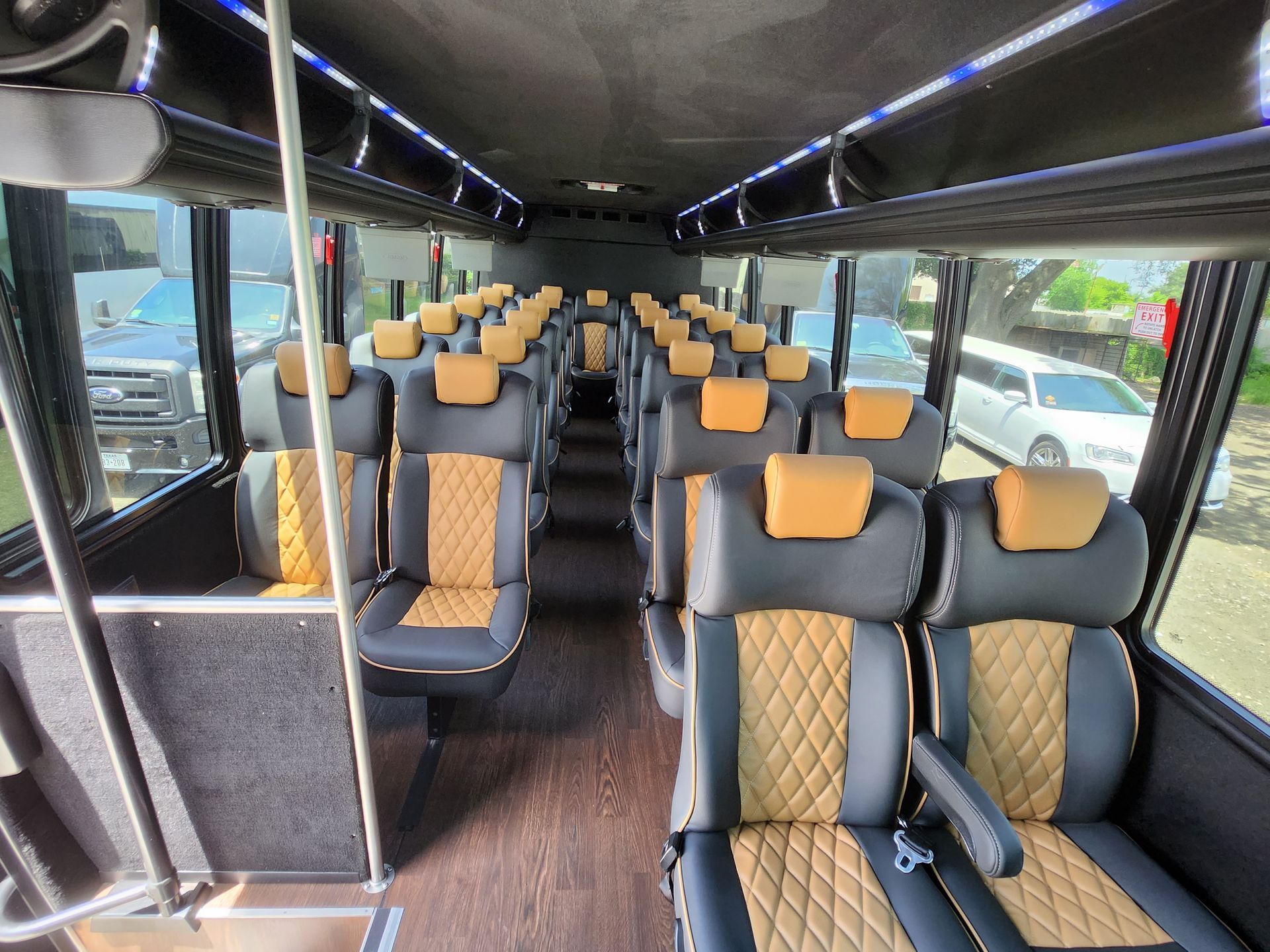 Interior of a bus with rows of black and tan leather seats