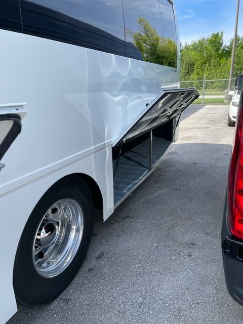 White bus with open storage compartment