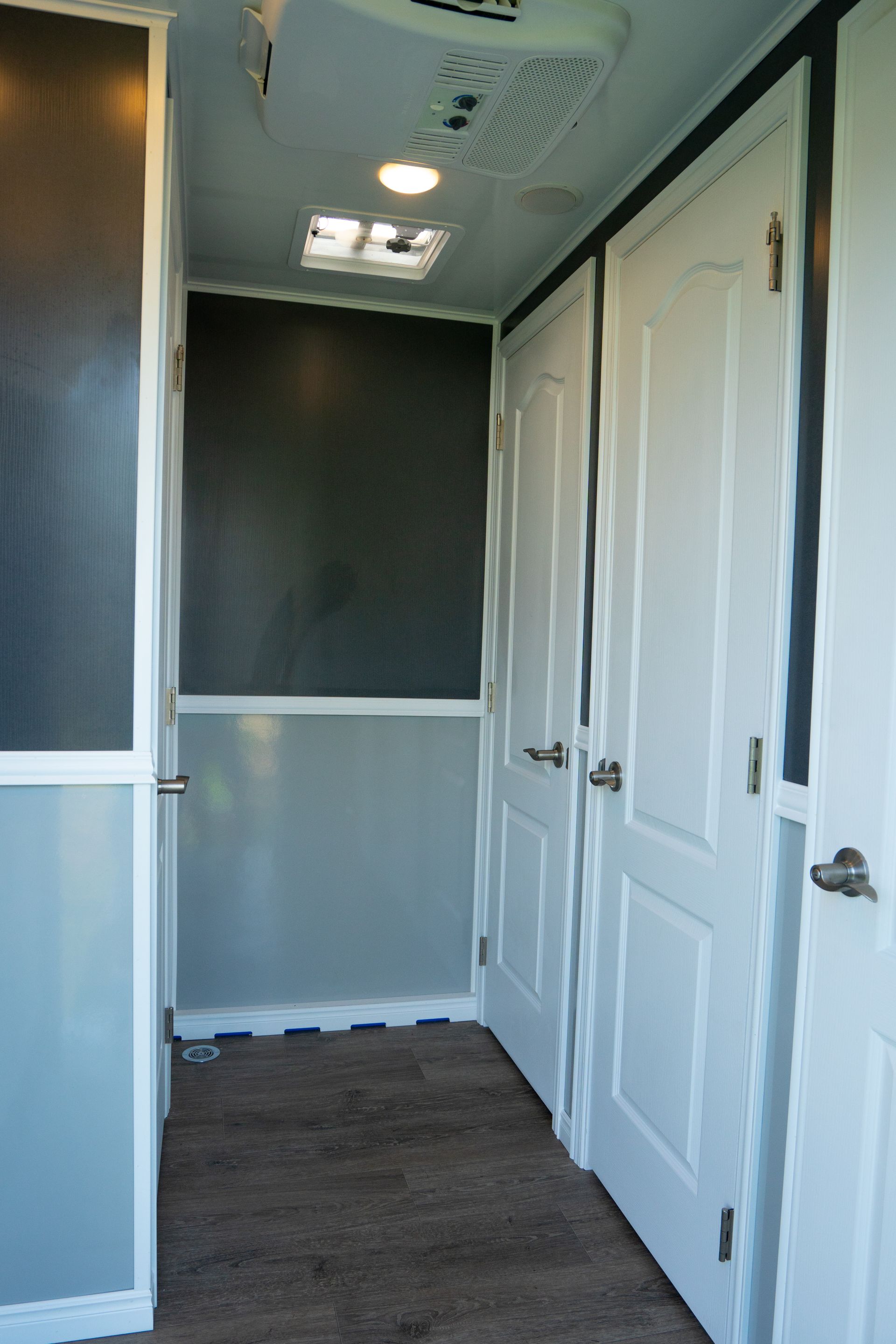 A hallway with white doors and a ceiling fan