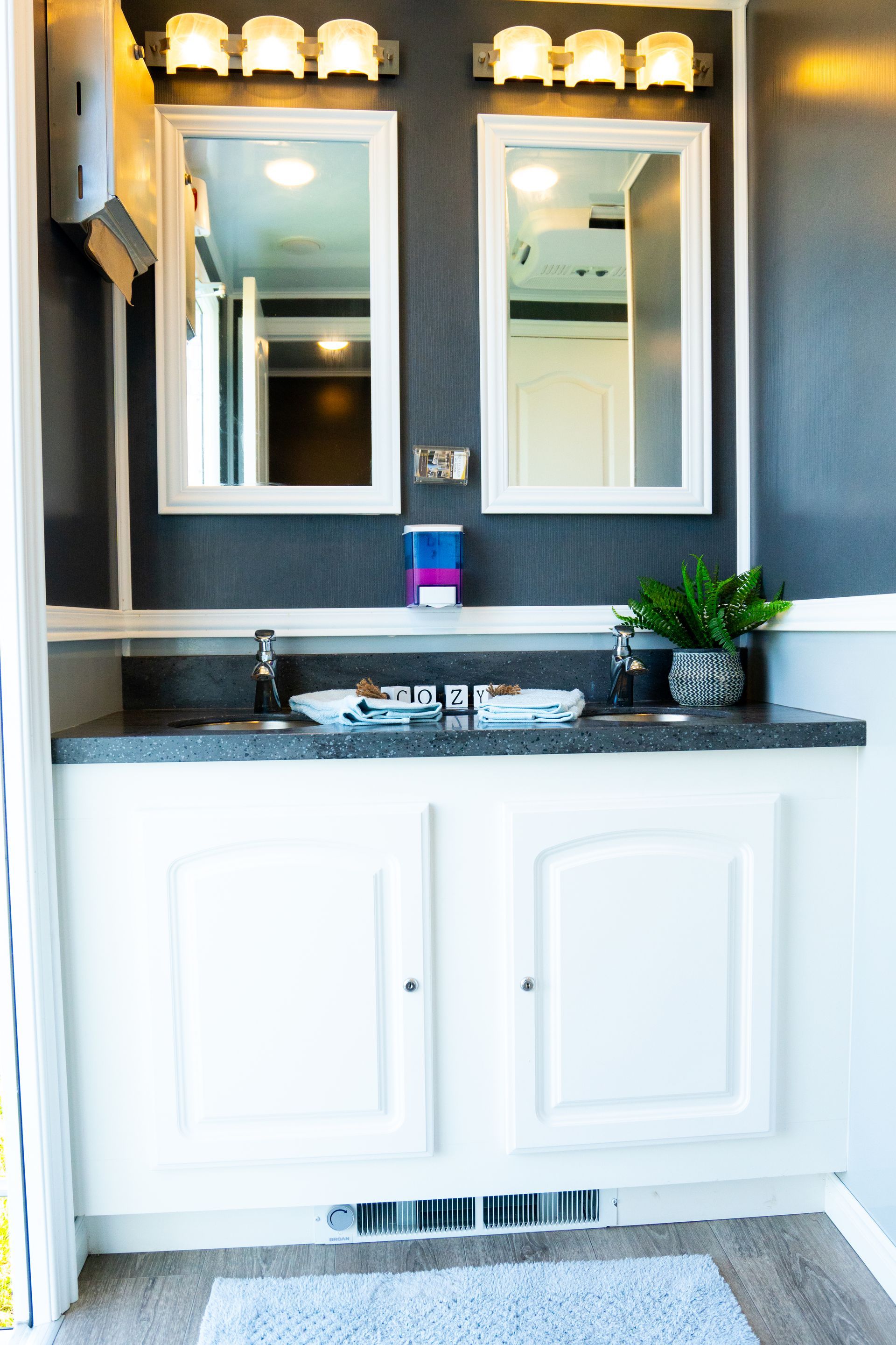 A bathroom with a sink and two mirrors.