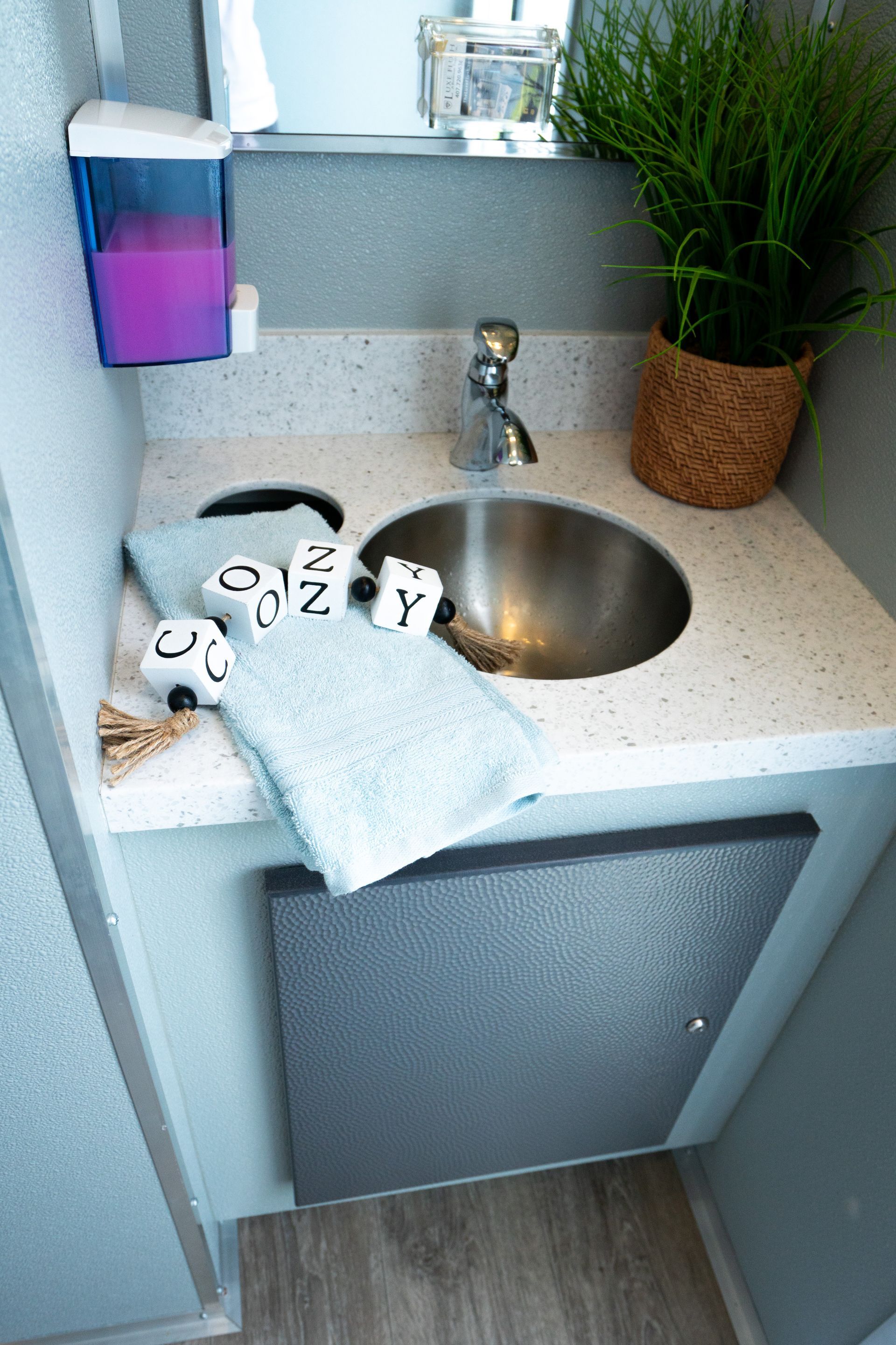 A bathroom sink with a towel and soap dispenser on the counter.