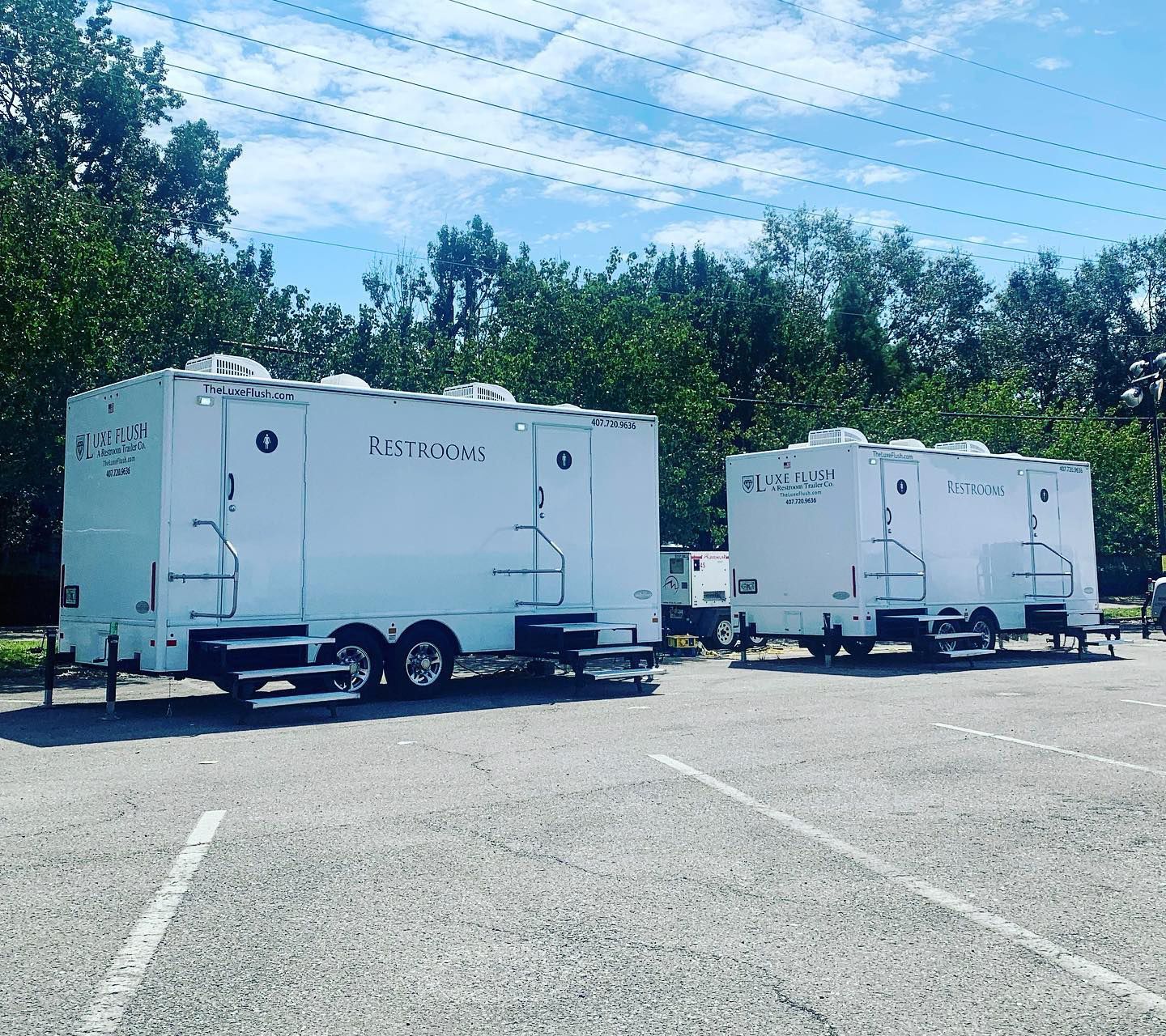A row of white trailers are parked in a parking lot