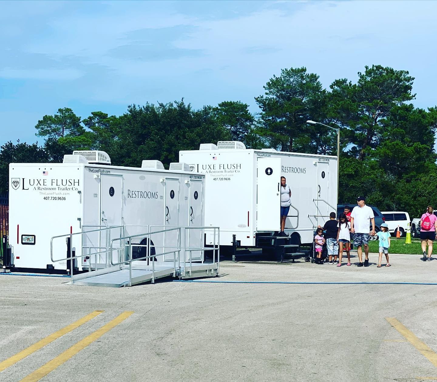 A group of people are standing in front of a row of trailers