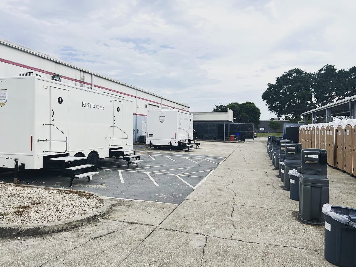 A row of white trailers are parked in front of a building