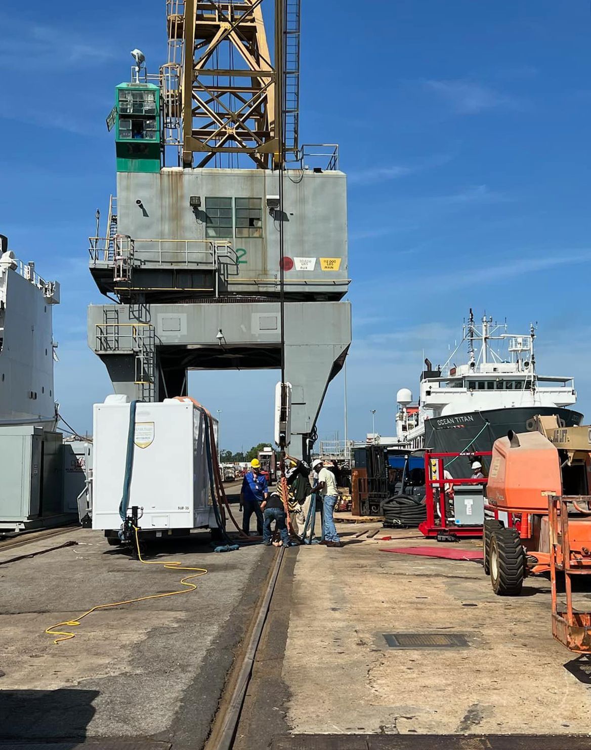 A large crane is being used to lift a white trailer