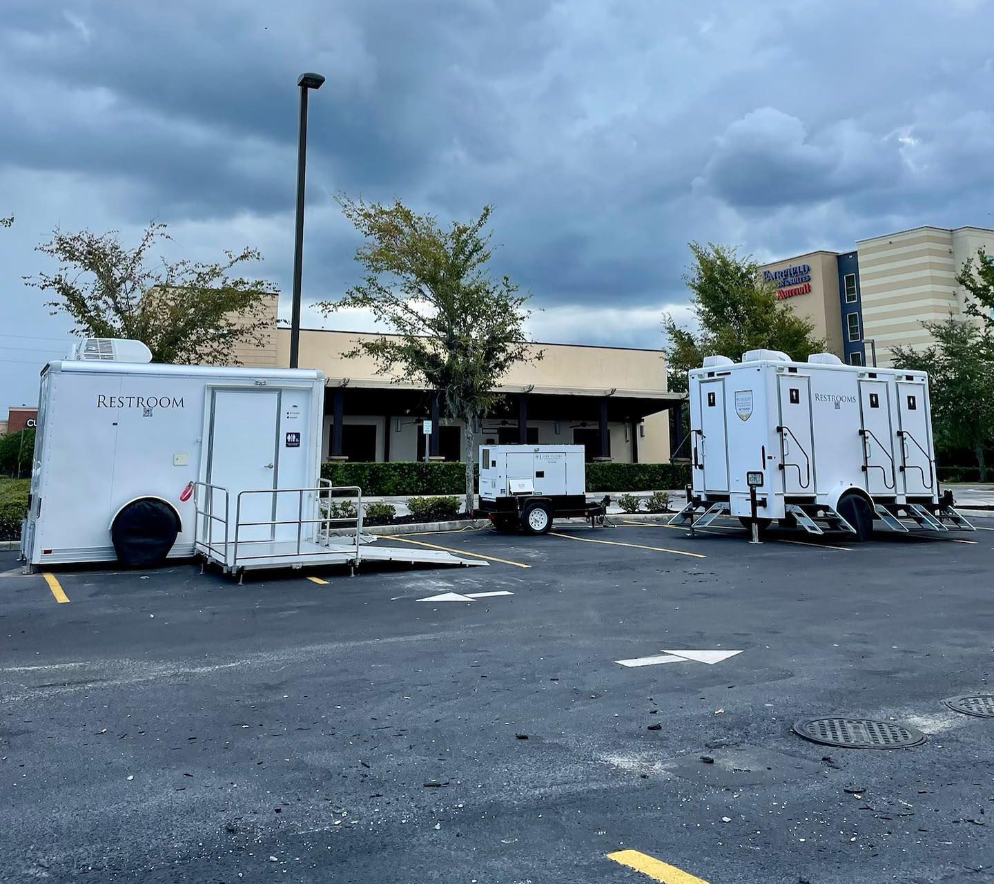 A row of white trailers are parked in a parking lot