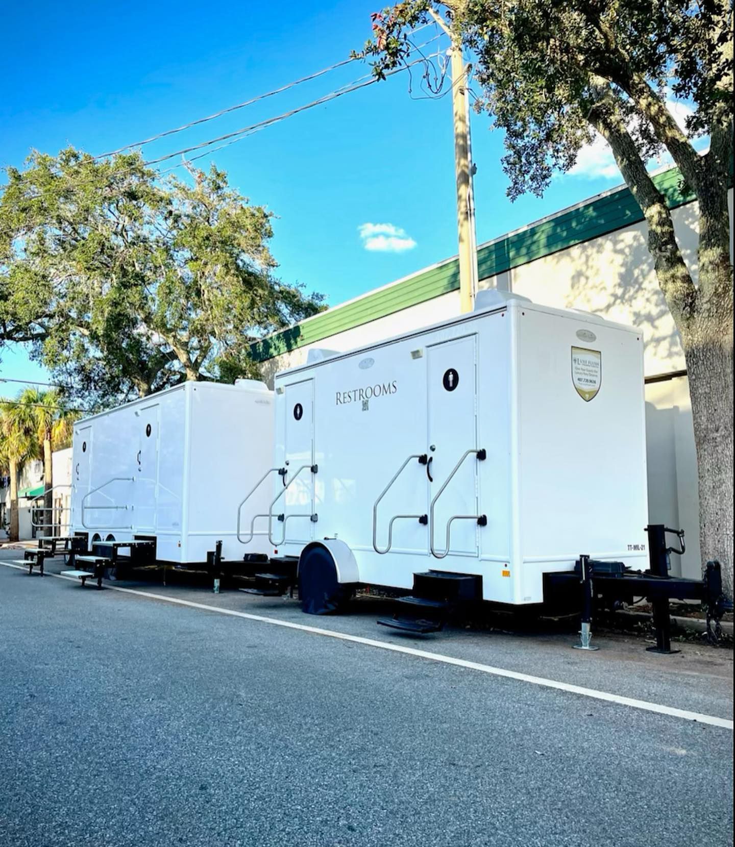 A row of white trailers are parked on the side of the road
