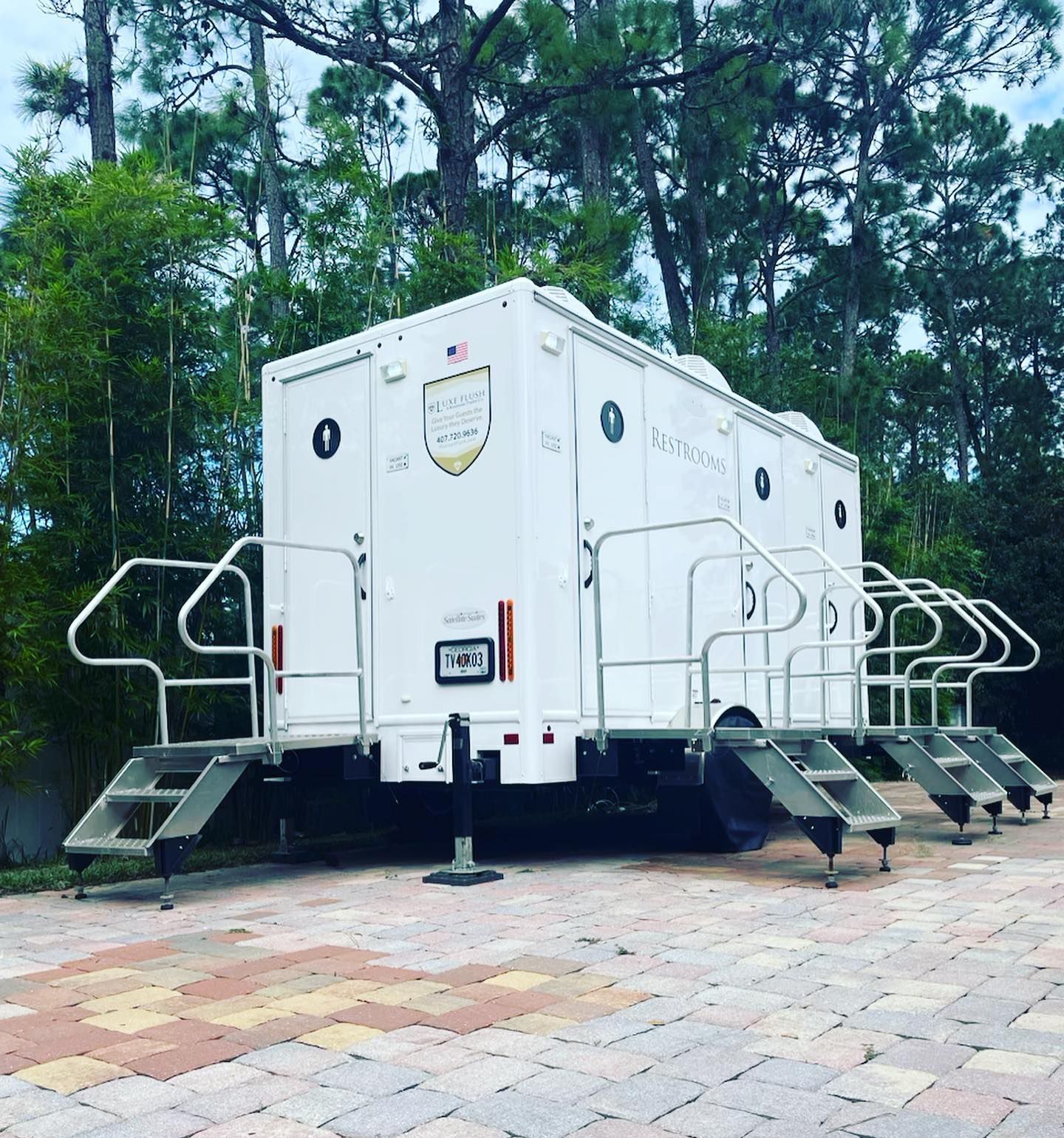 A white trailer with stairs and a shield on it