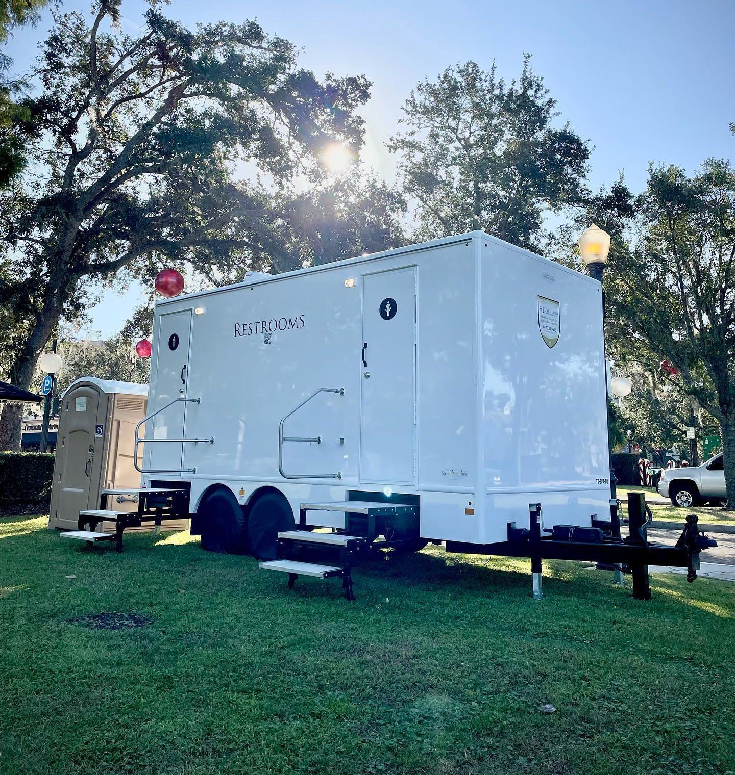 A white trailer is parked in a grassy field