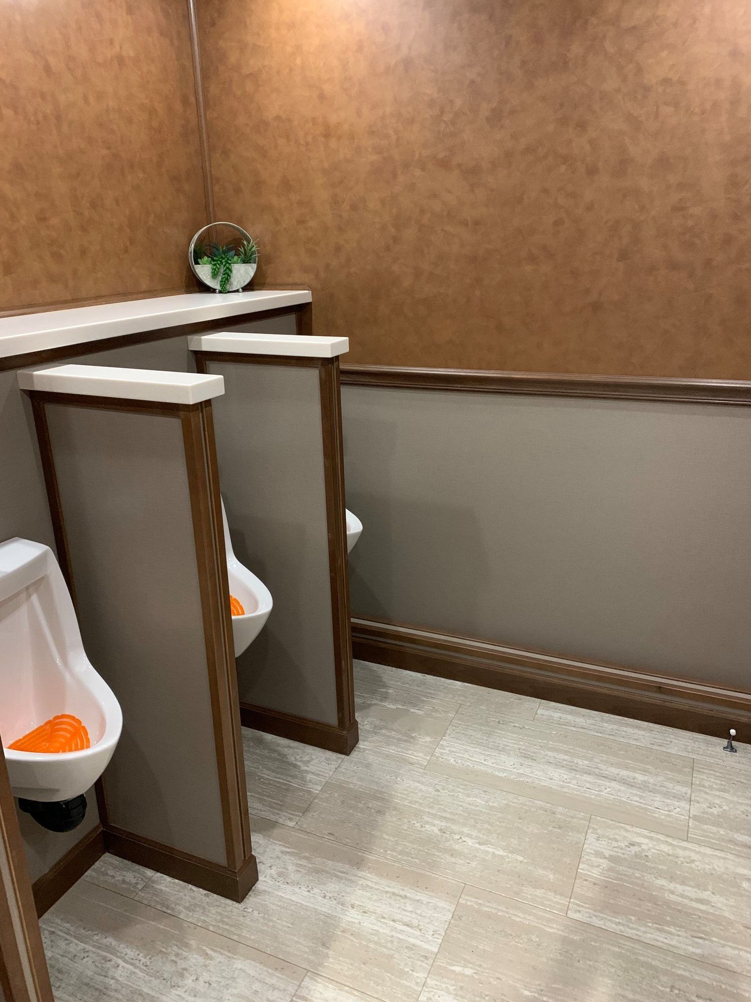 A bathroom with two urinals and a toilet