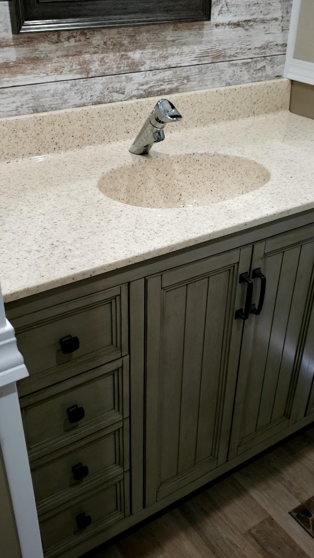 A bathroom vanity with a sink and a faucet