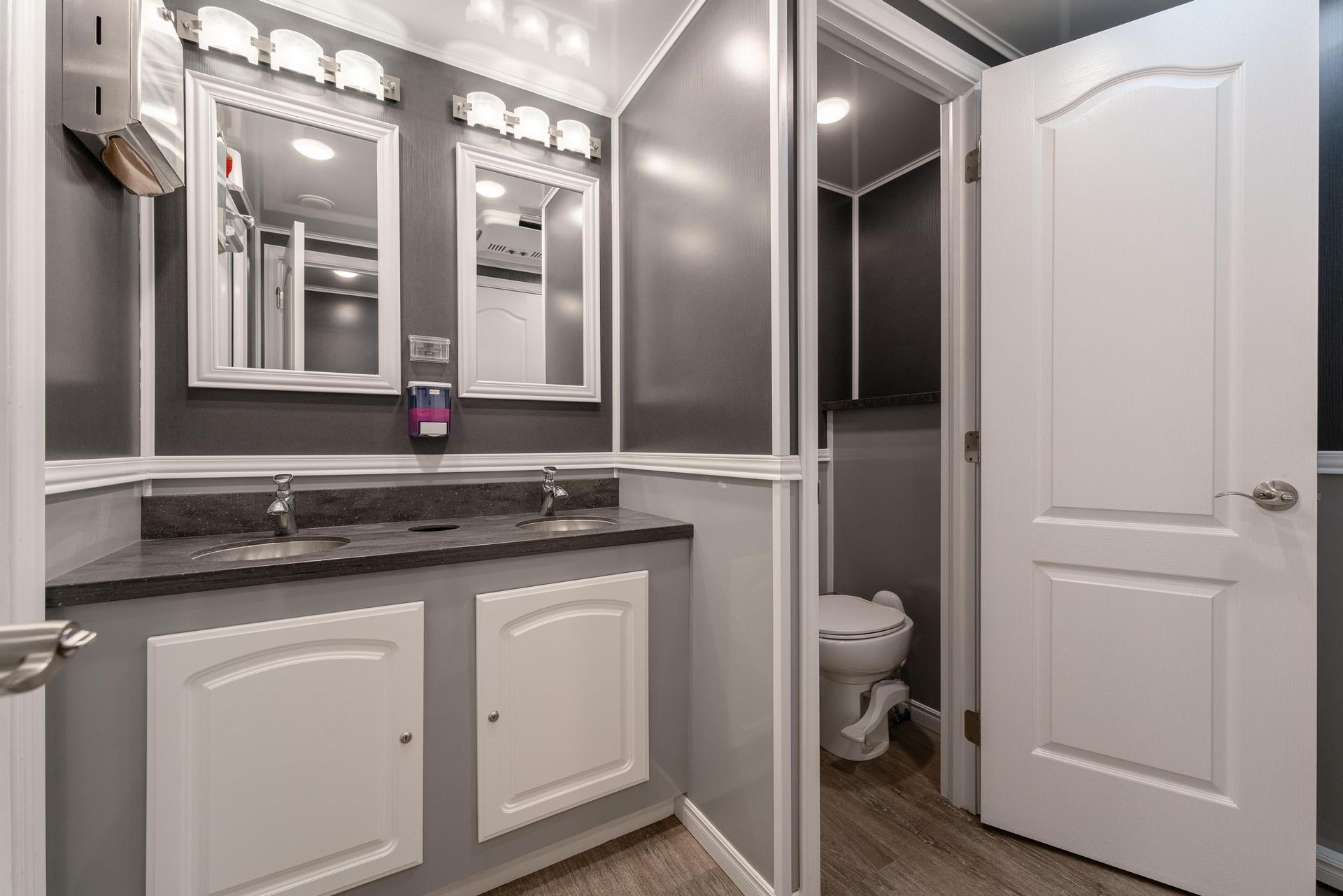 A bathroom with two sinks and a toilet