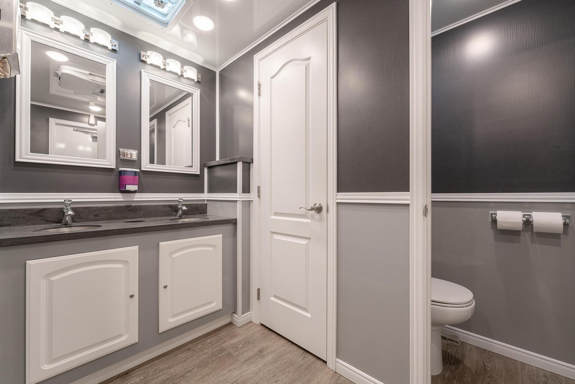 A bathroom with two sinks and a toilet