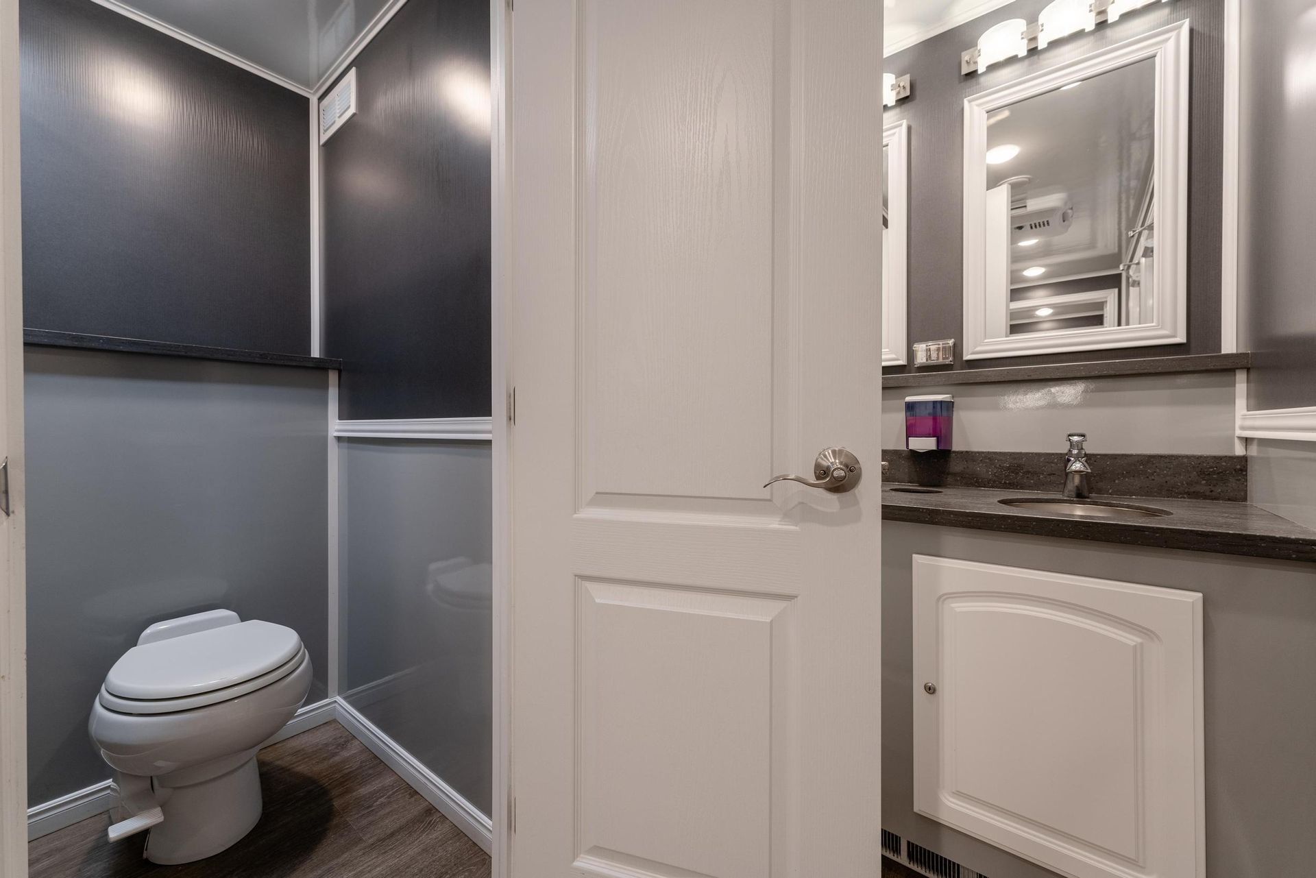 A bathroom with a toilet, sink, and mirror