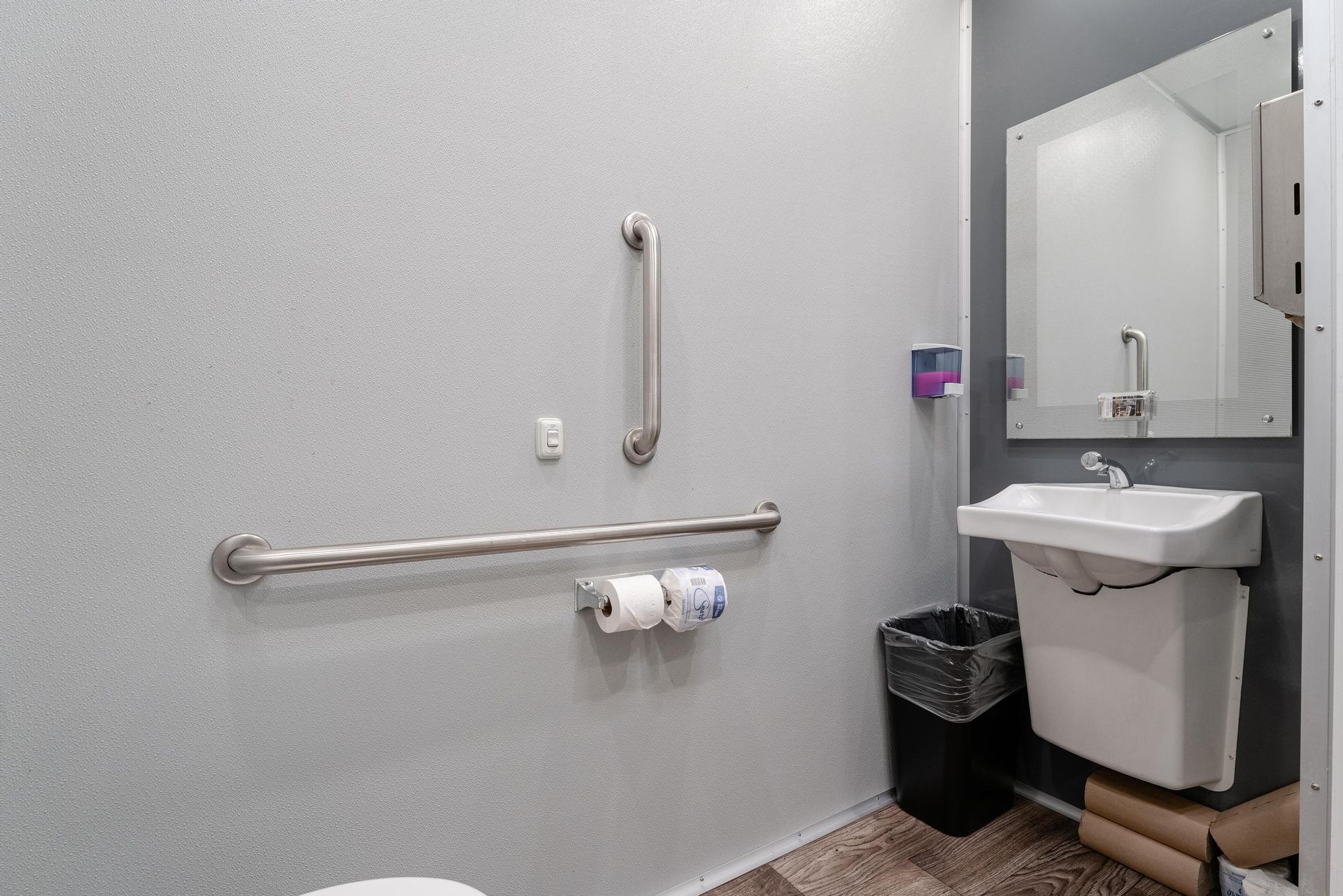 A bathroom with a toilet, sink, and mirror