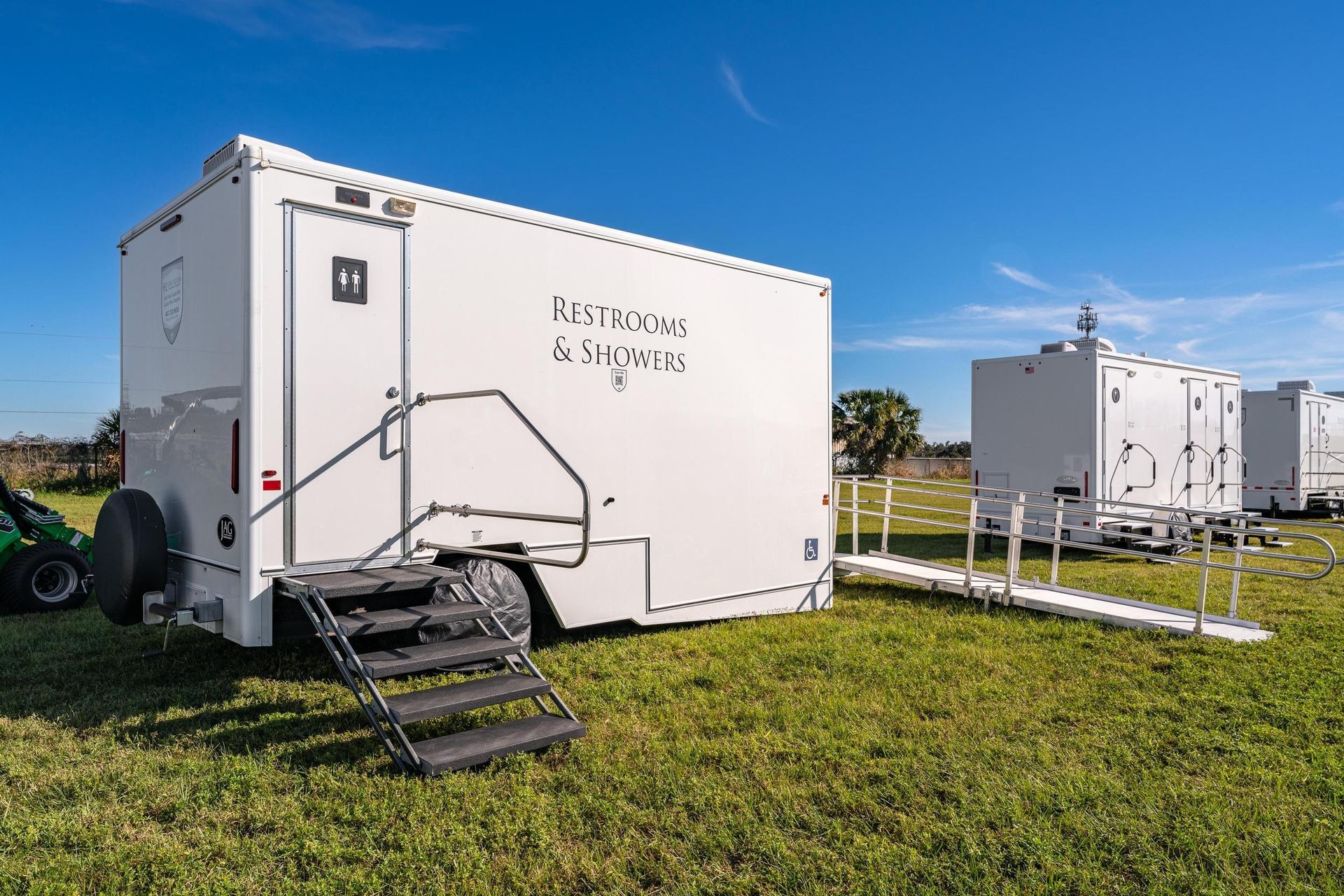 Three portable toilets are sitting next to each other in a parking lot