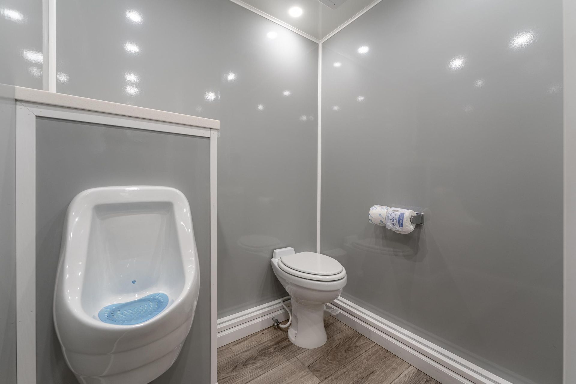 A bathroom with a urinal and a toilet