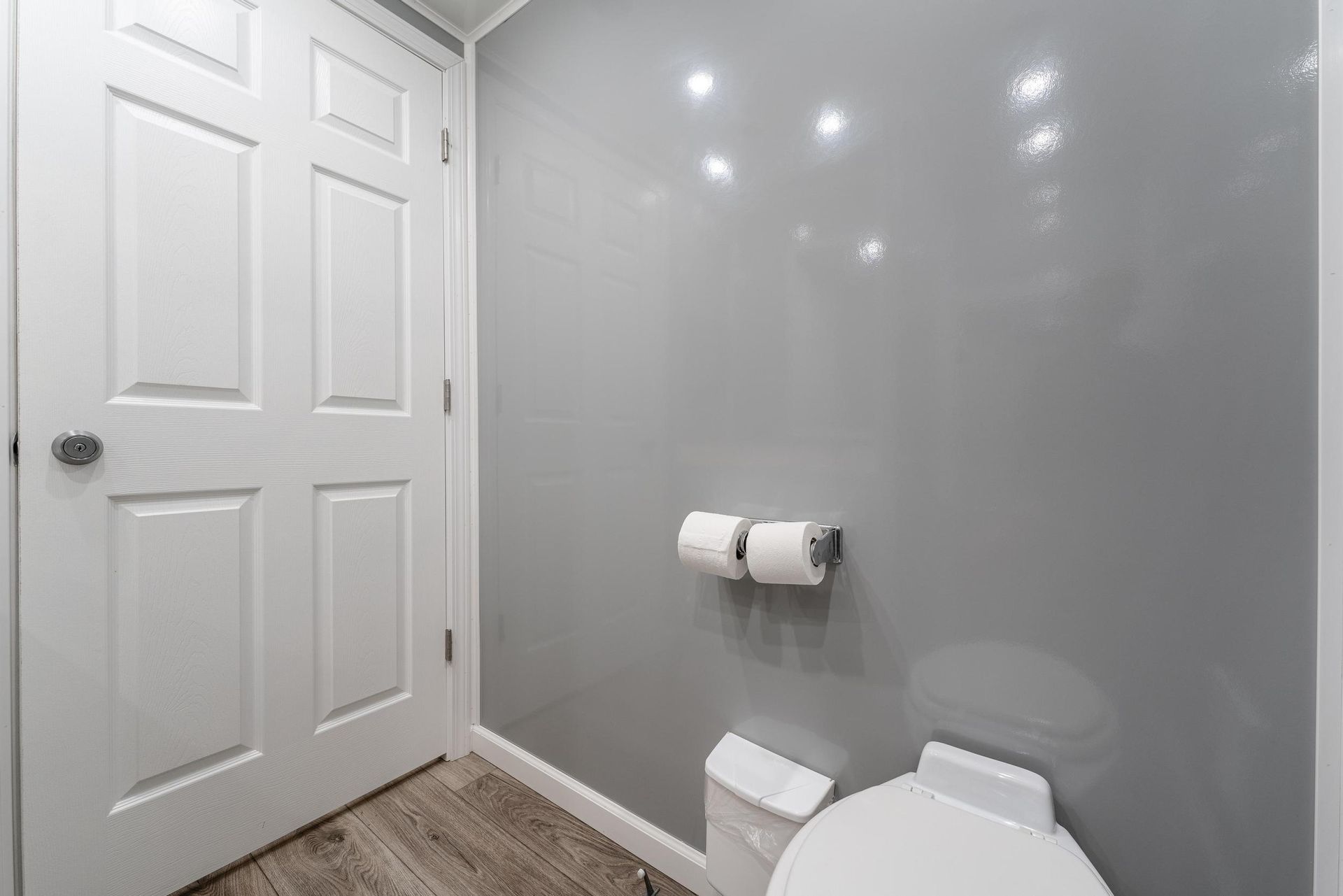 A bathroom with a toilet and two rolls of toilet paper