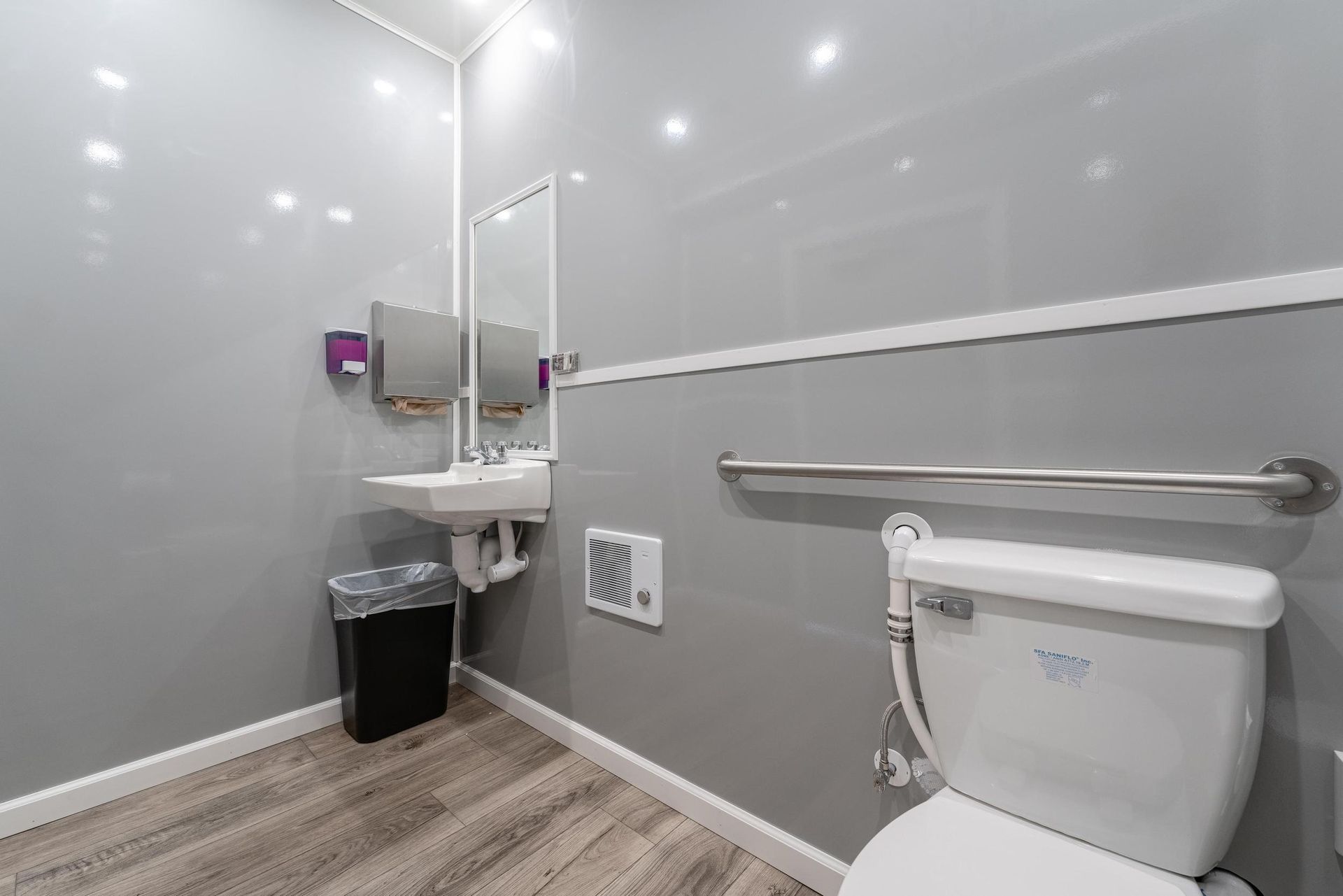 A bathroom with a toilet, sink, and mirror