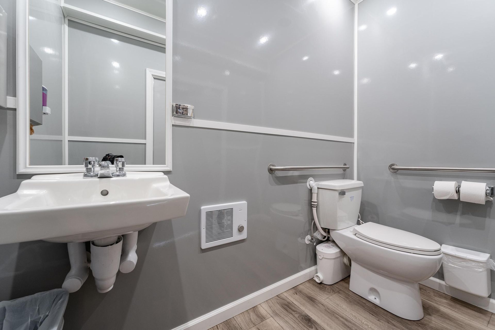 A bathroom with a sink, toilet, and mirror