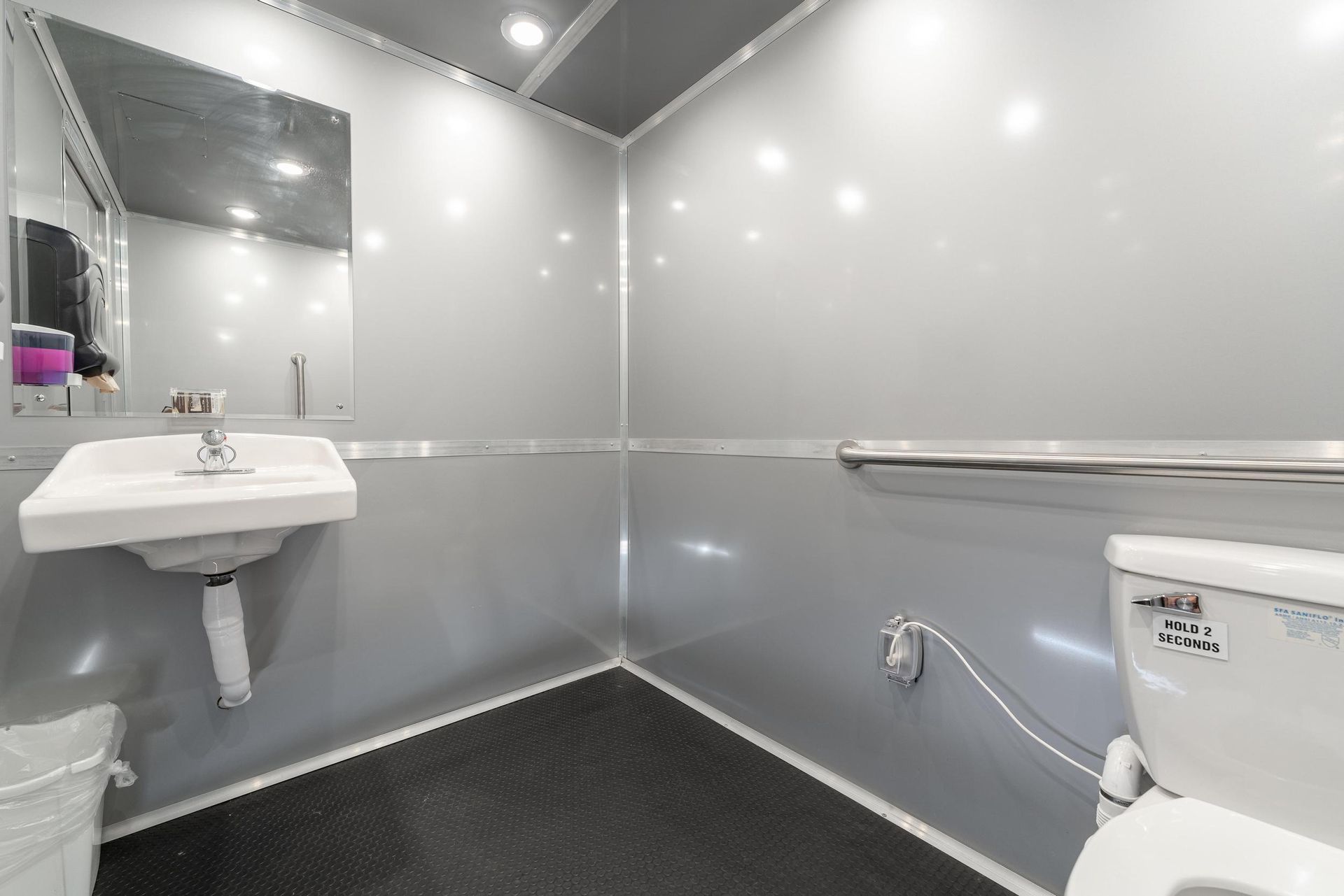 A bathroom with a sink, toilet, and mirror