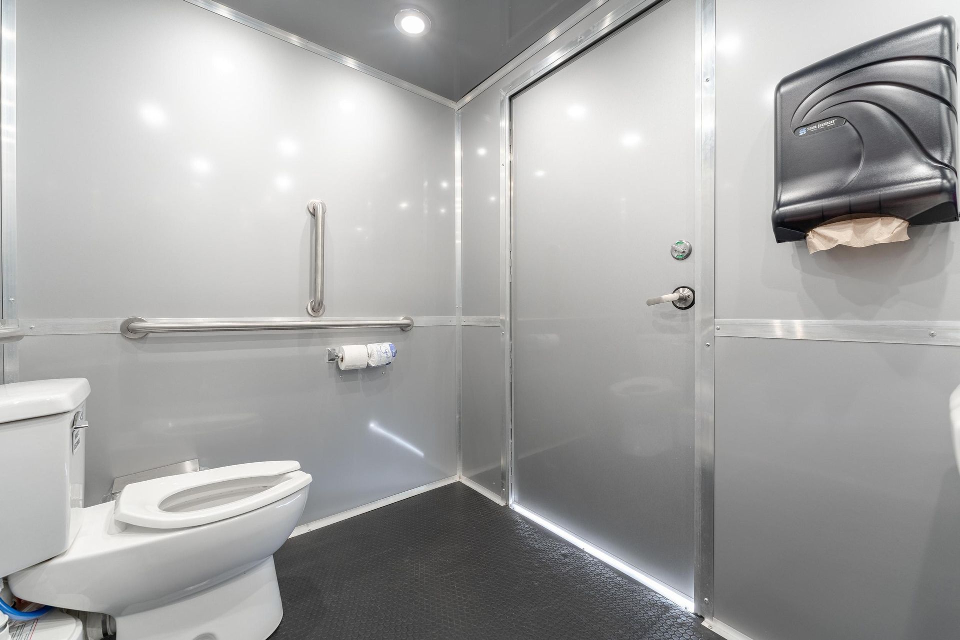 A bathroom with a toilet and a hand rail