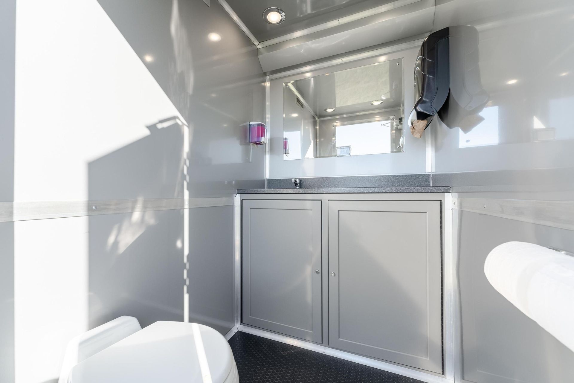 A bathroom with a toilet, sink, and mirror