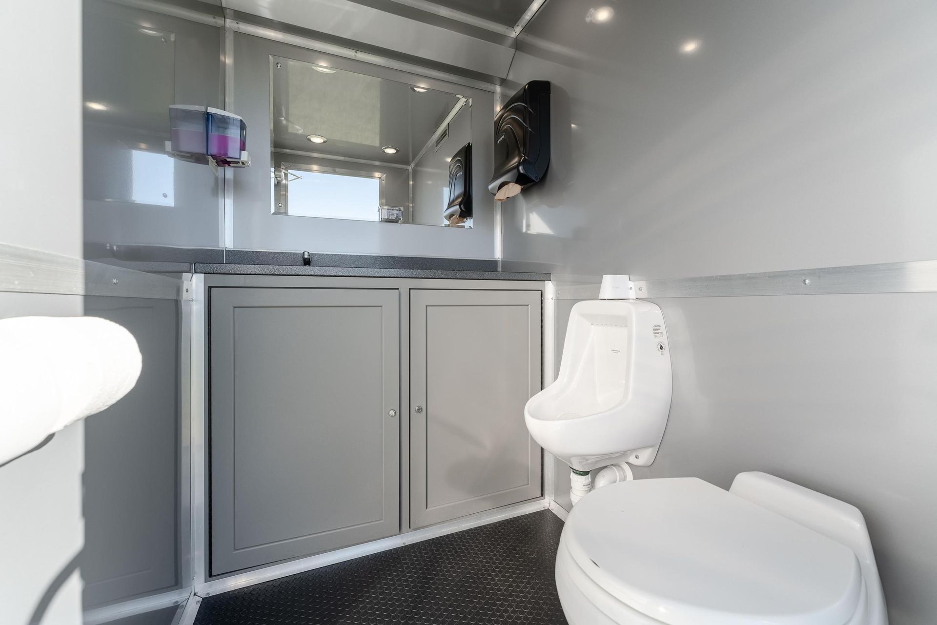 A bathroom with a toilet, sink, and mirror