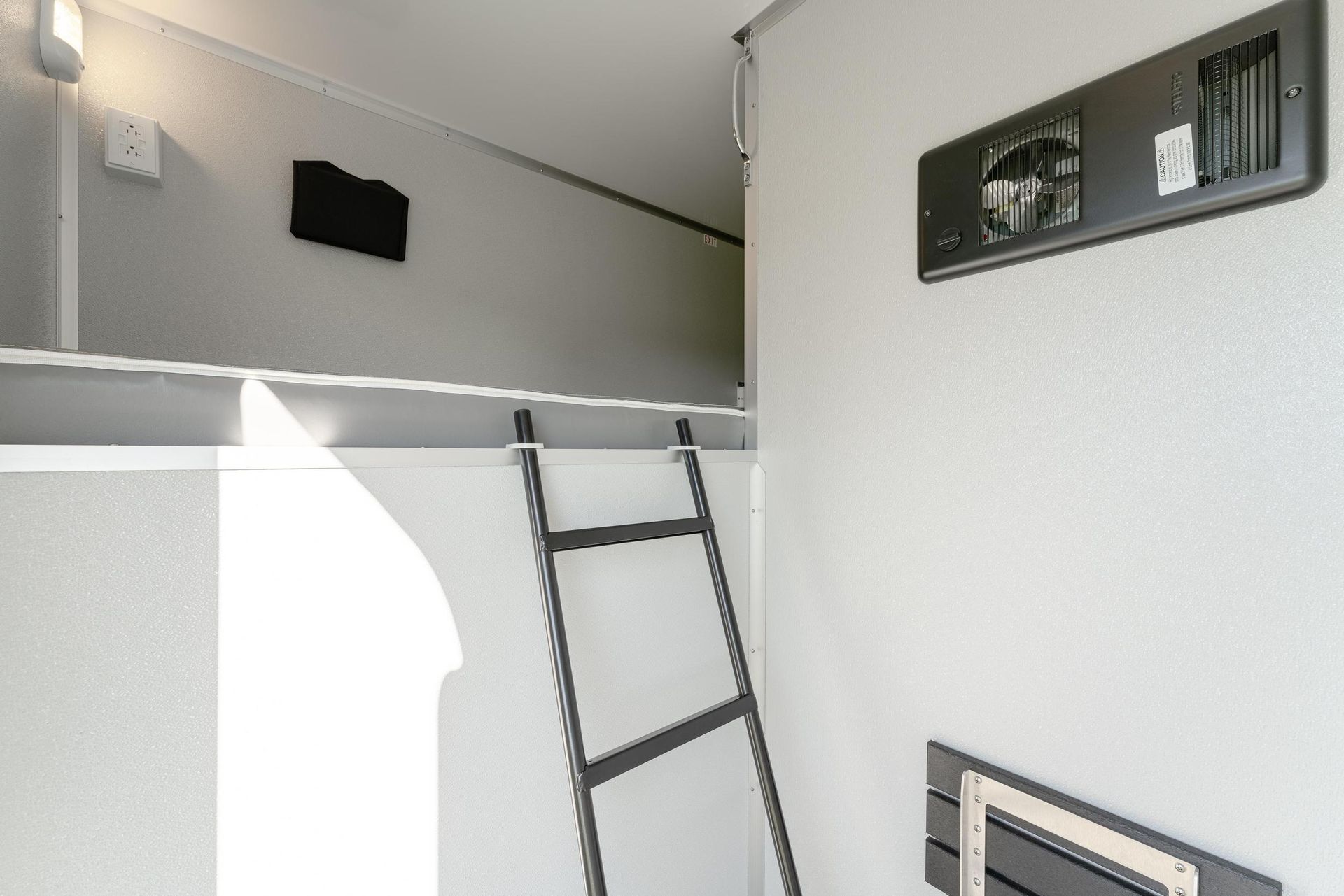 A room with a ladder leading up to a loft bed