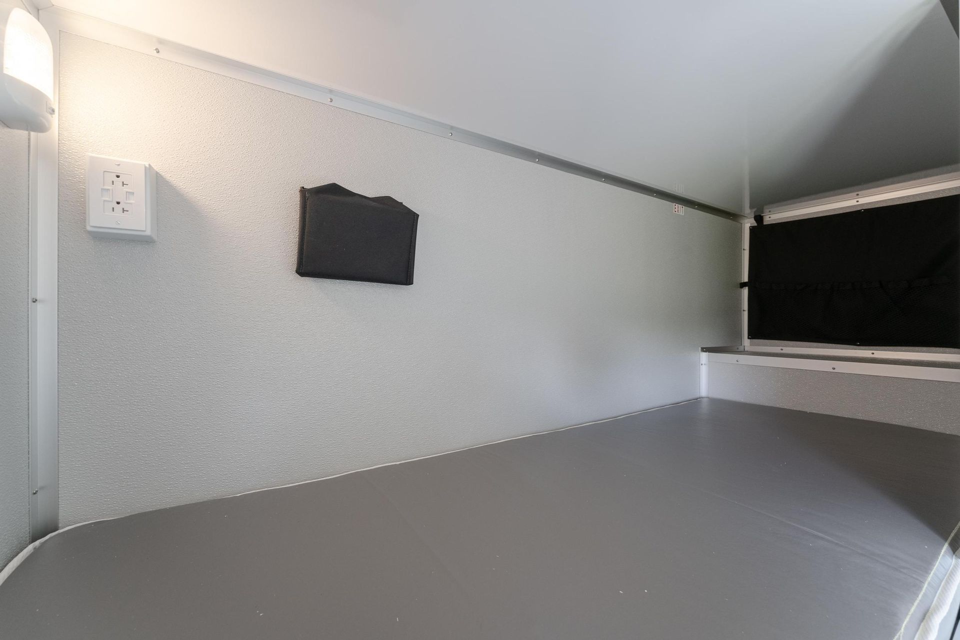 A bedroom with a bed and a television on the wall