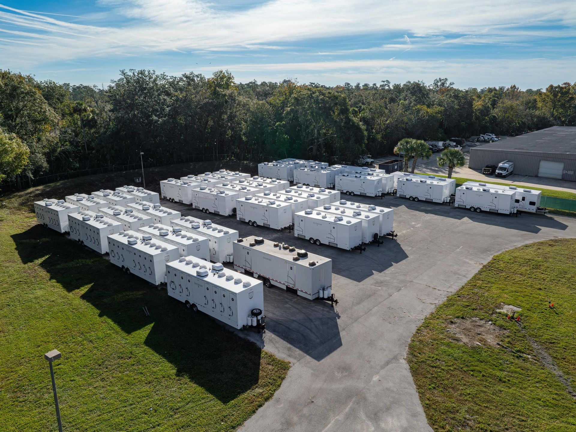 An aerial view of a warehouse filled with lots of white trailers