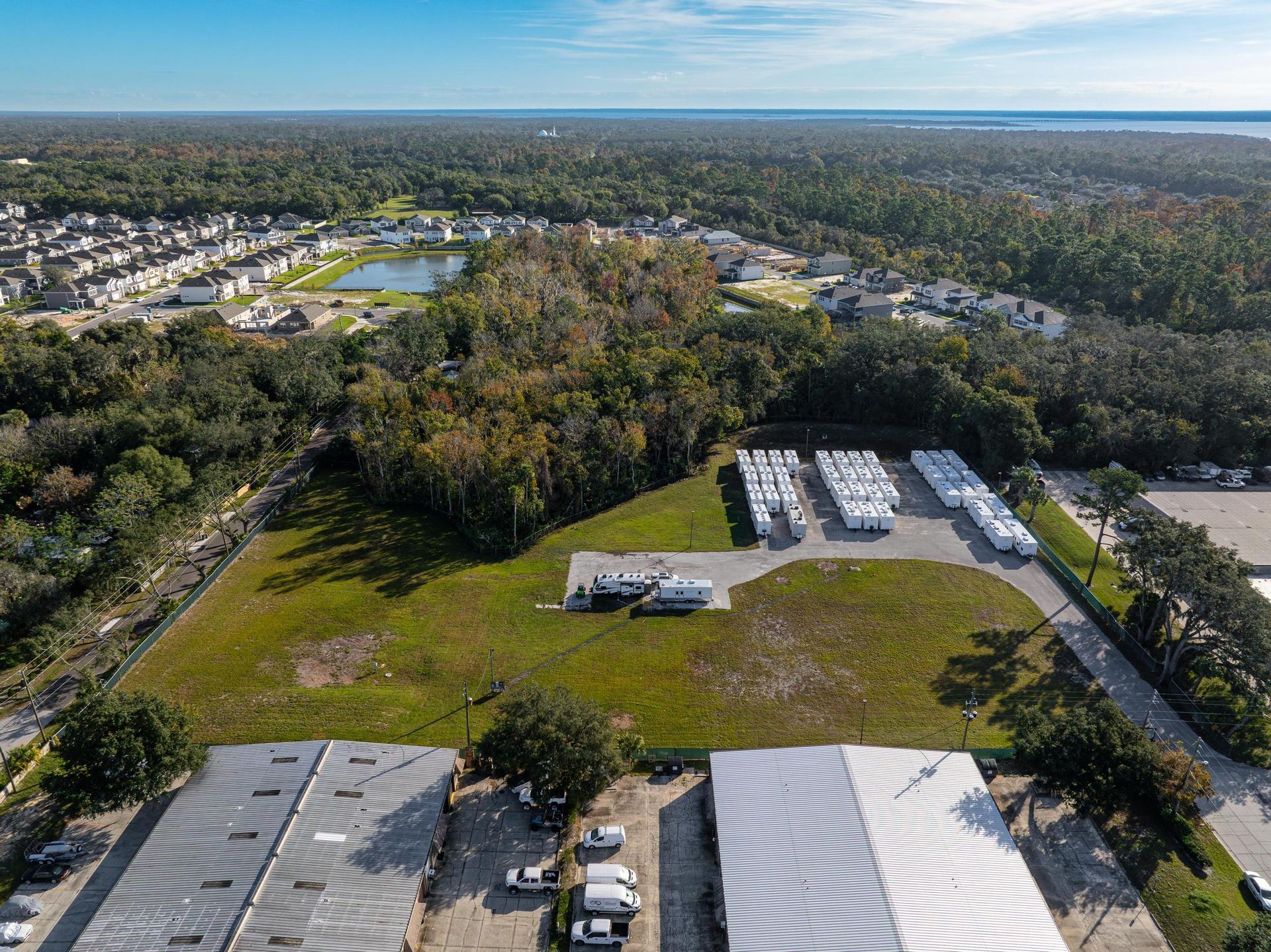 An aerial view of a large warehouse surrounded by trees