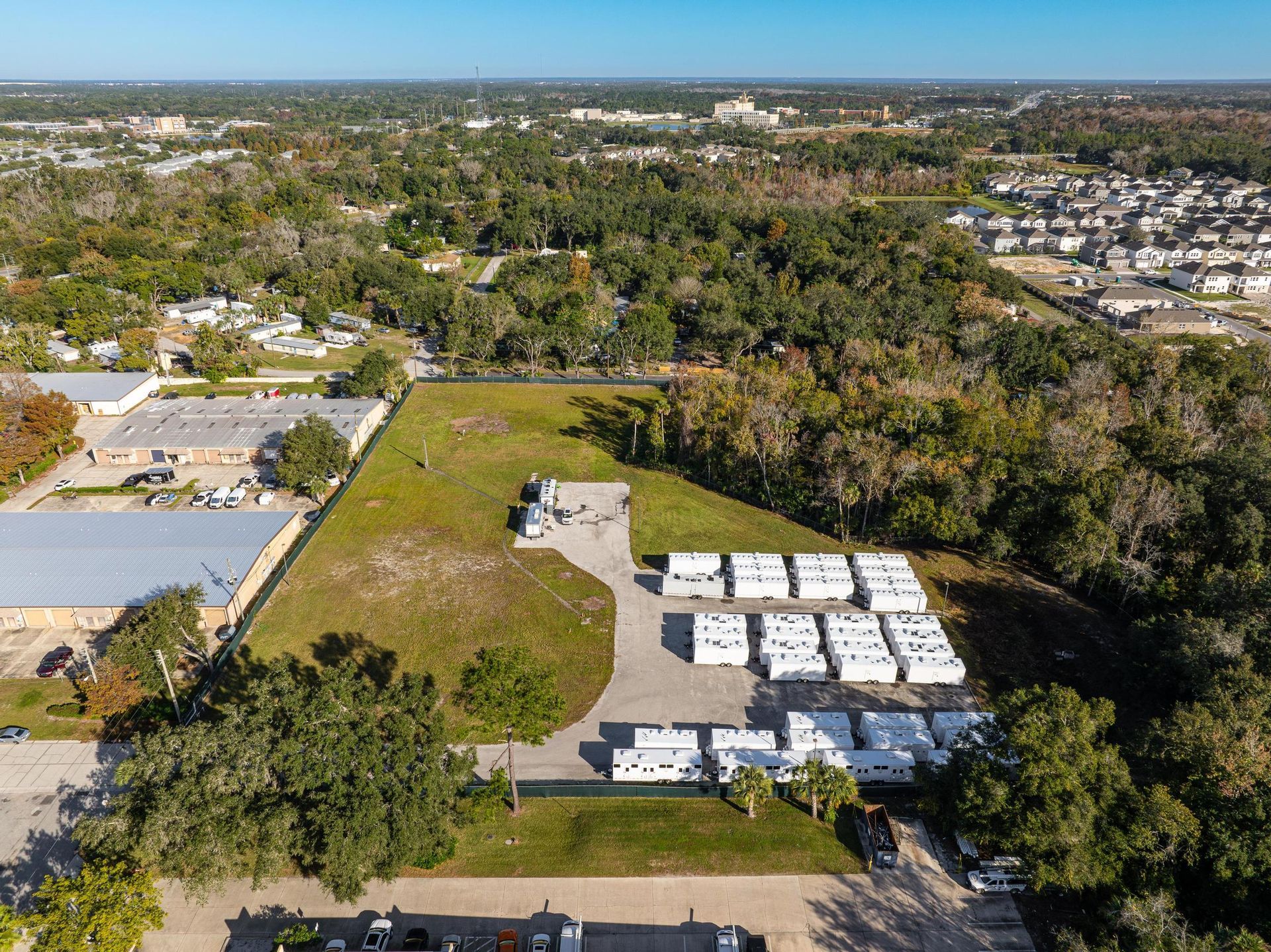 An aerial view of a large field with a lot of trailers parked in it
