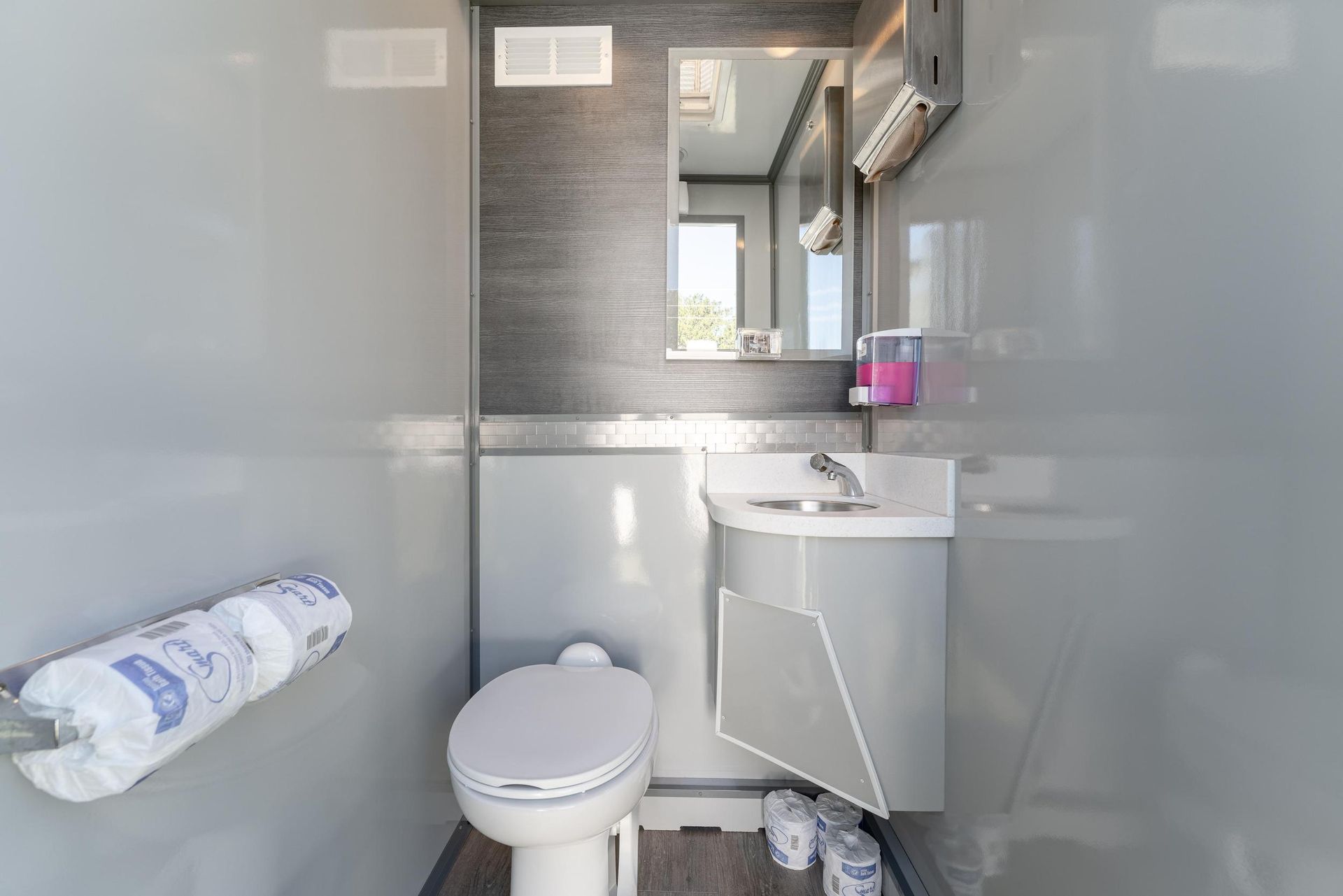 A bathroom with a toilet, sink, and mirror