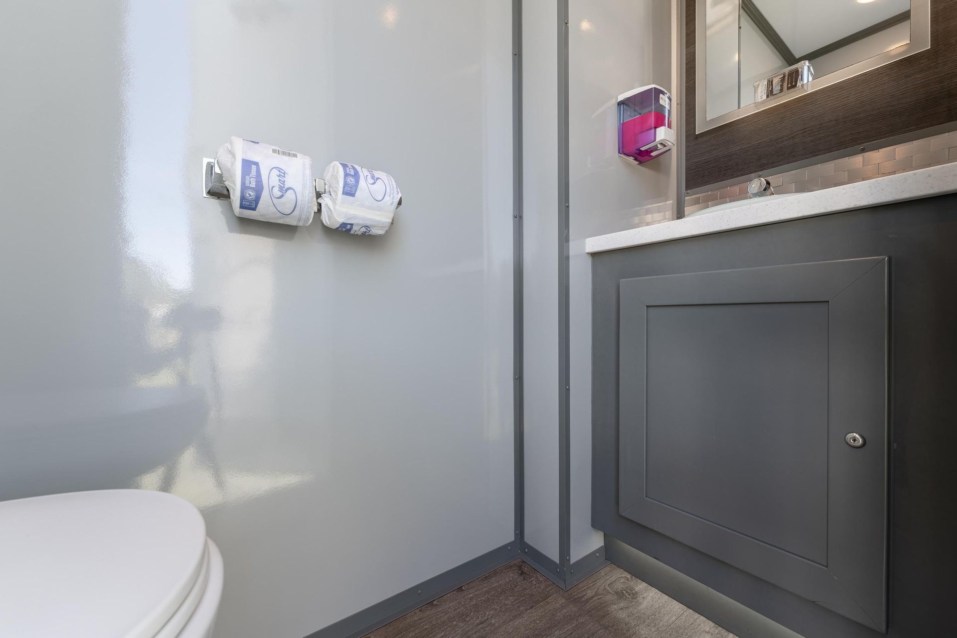 A bathroom with a toilet, sink, and mirror