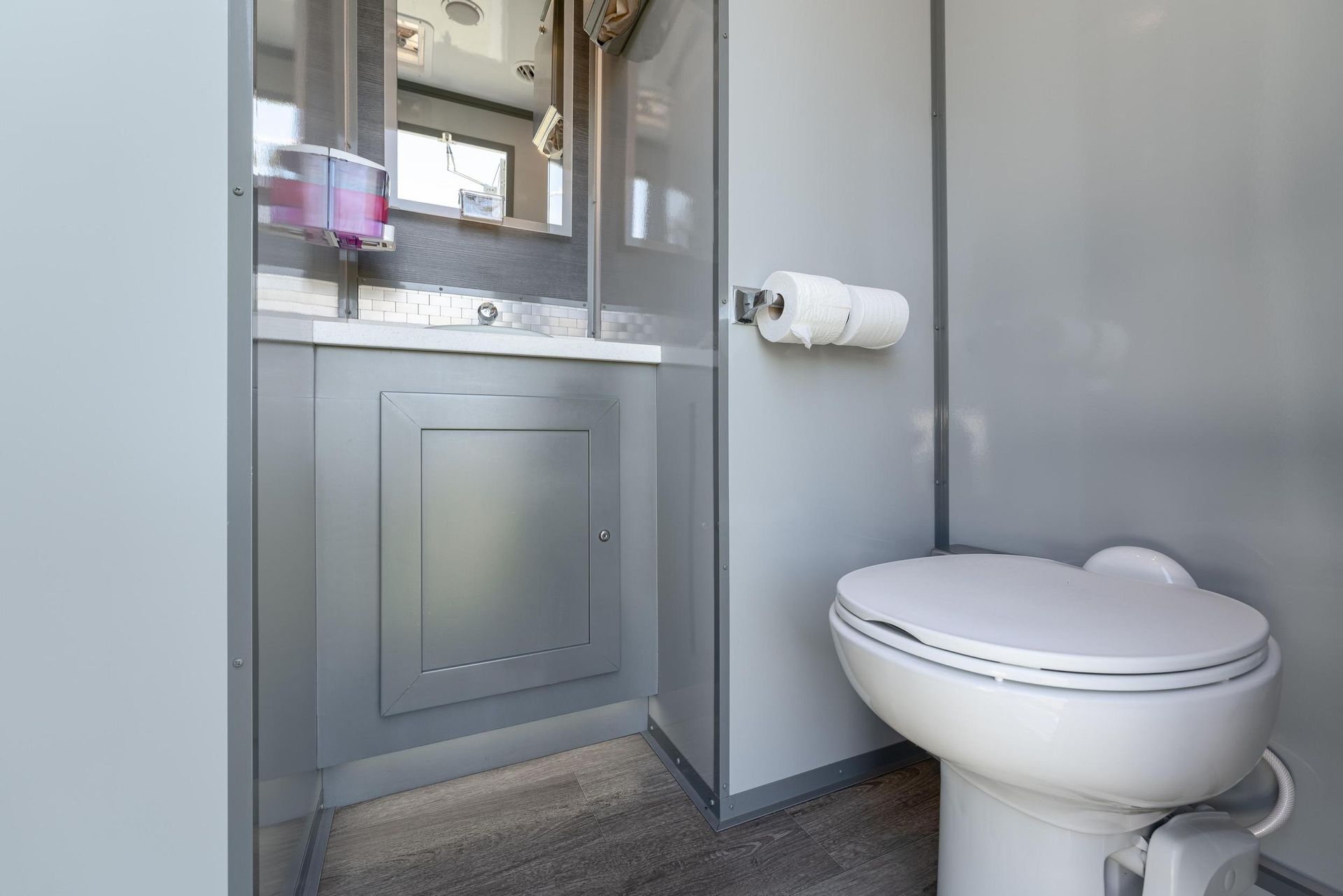 A bathroom with a toilet, sink, and mirror