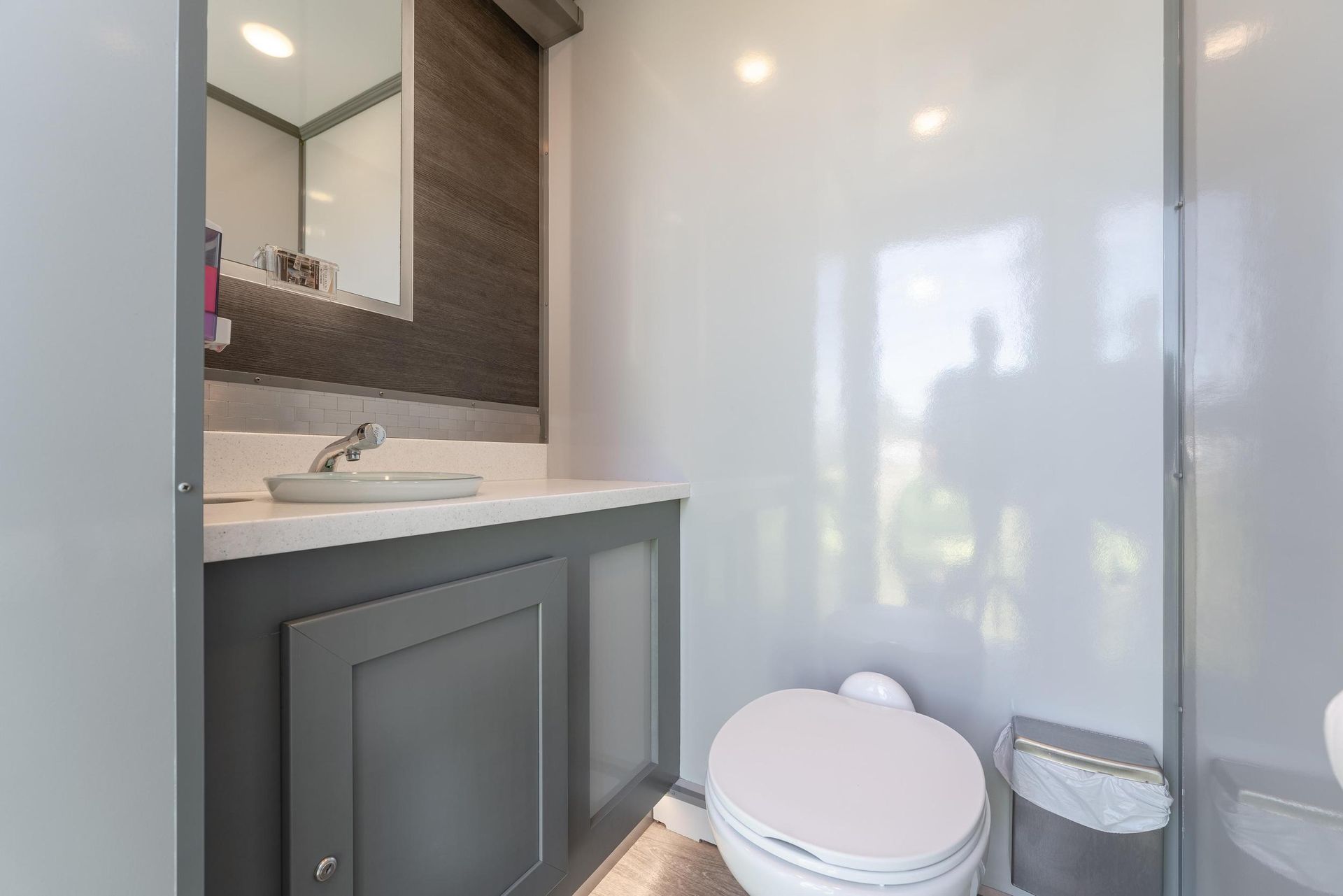 A bathroom with a toilet, sink, and mirror