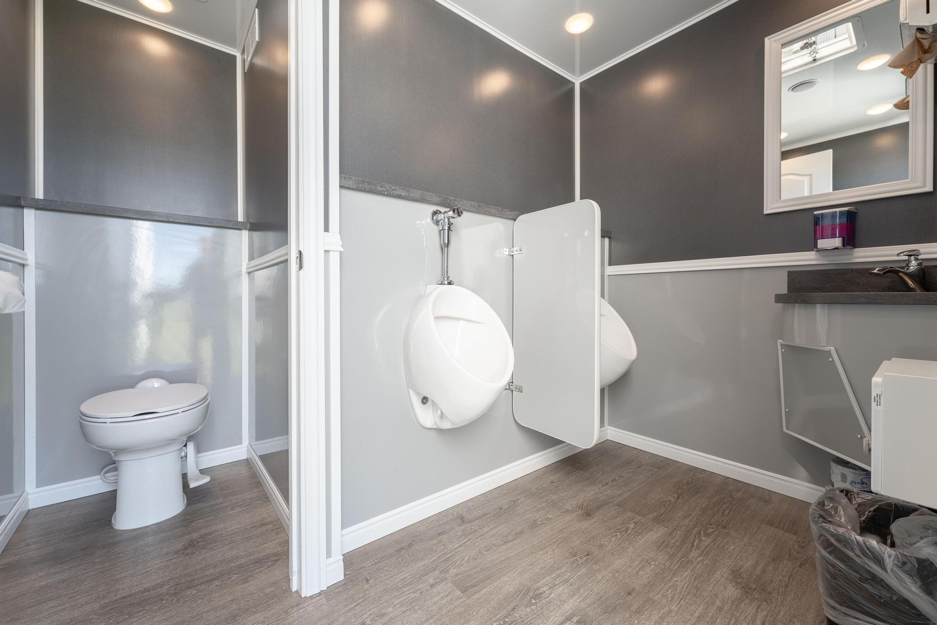 A bathroom with a toilet, urinals, and a sink