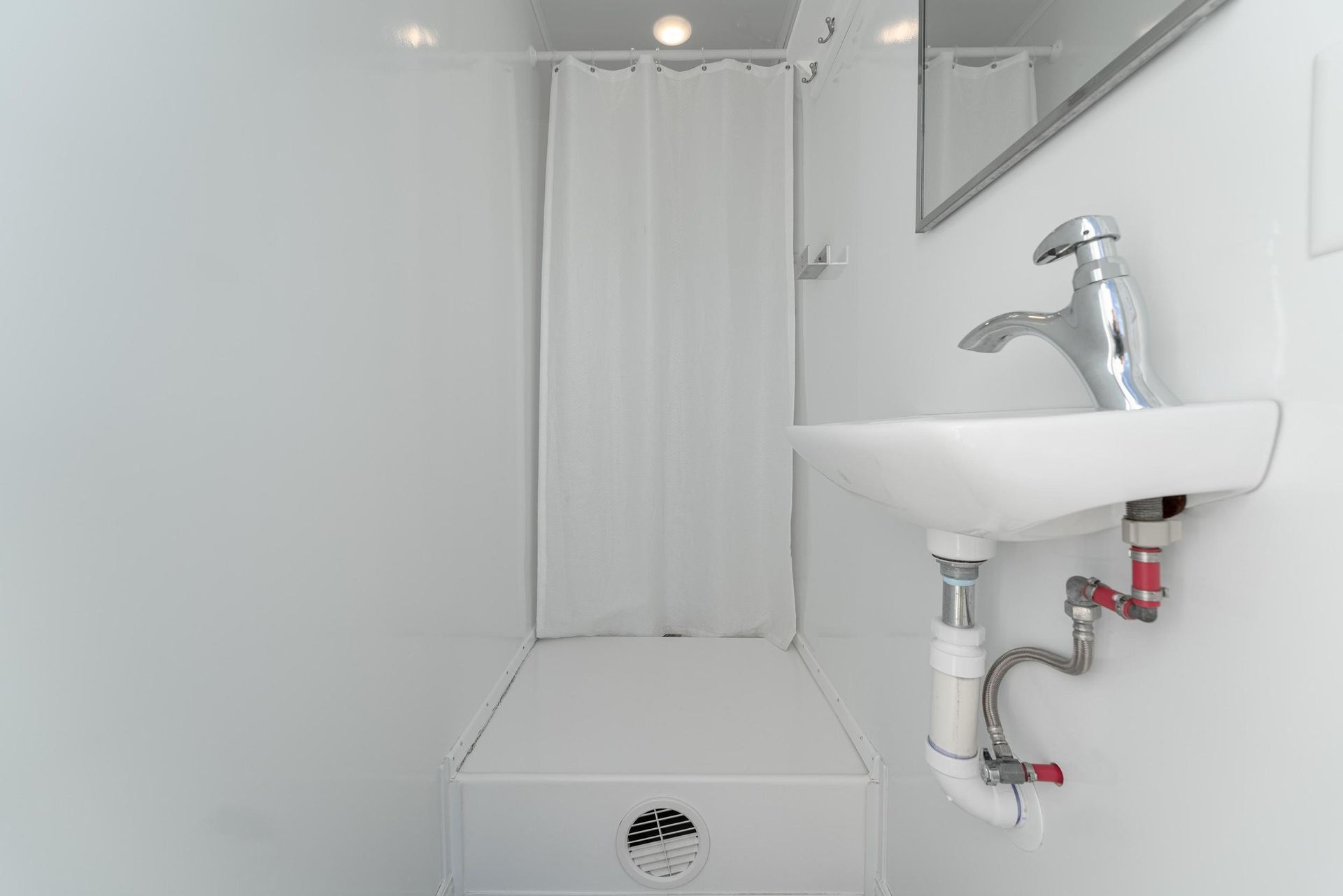 A bathroom with a sink, mirror,and shower