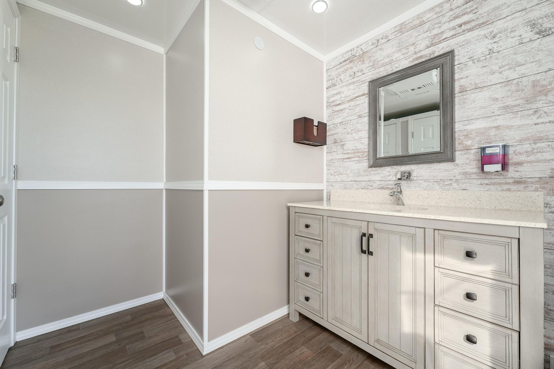 A bathroom with a sink, mirror, and walk in shower