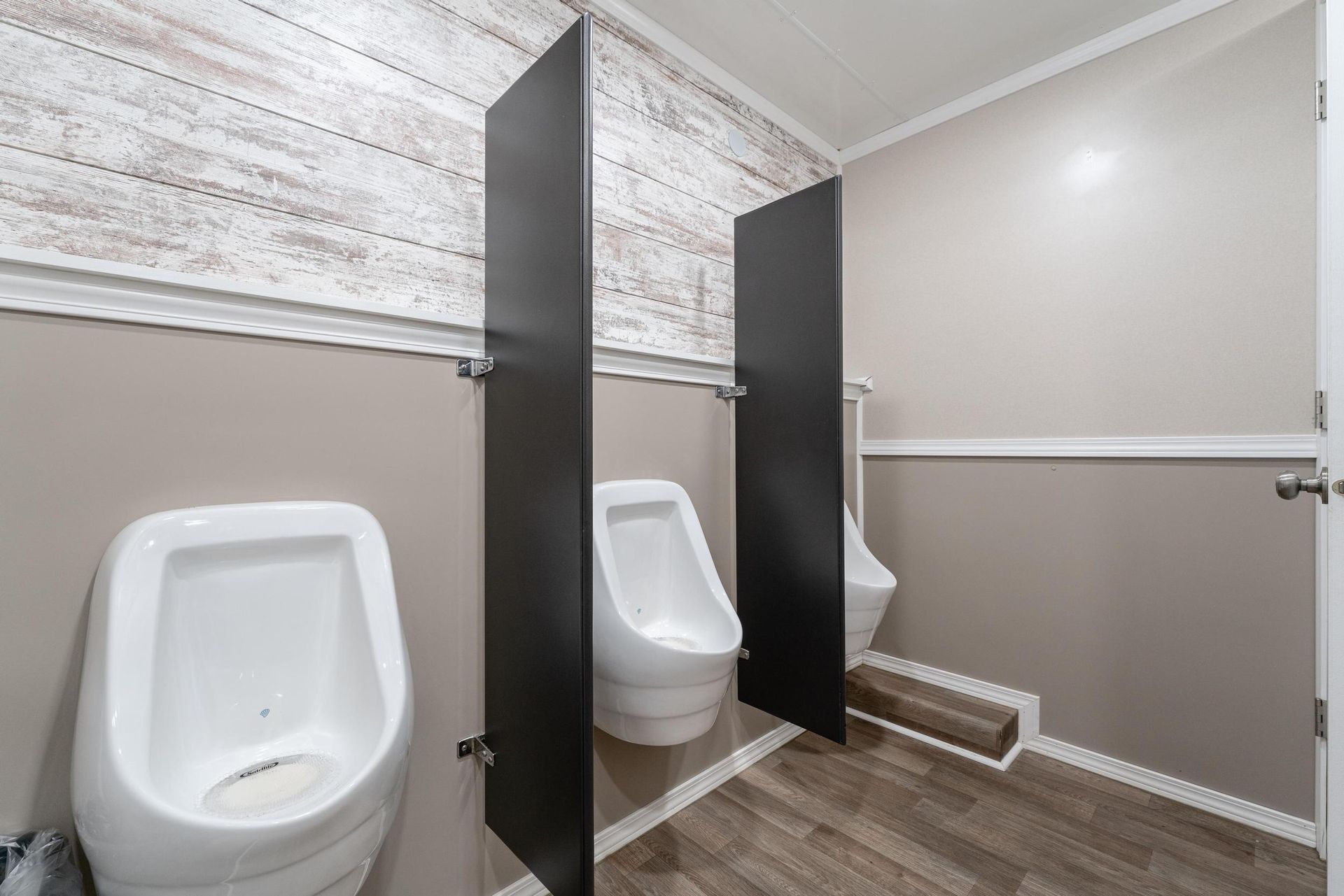 A bathroom with two urinals and two toilets