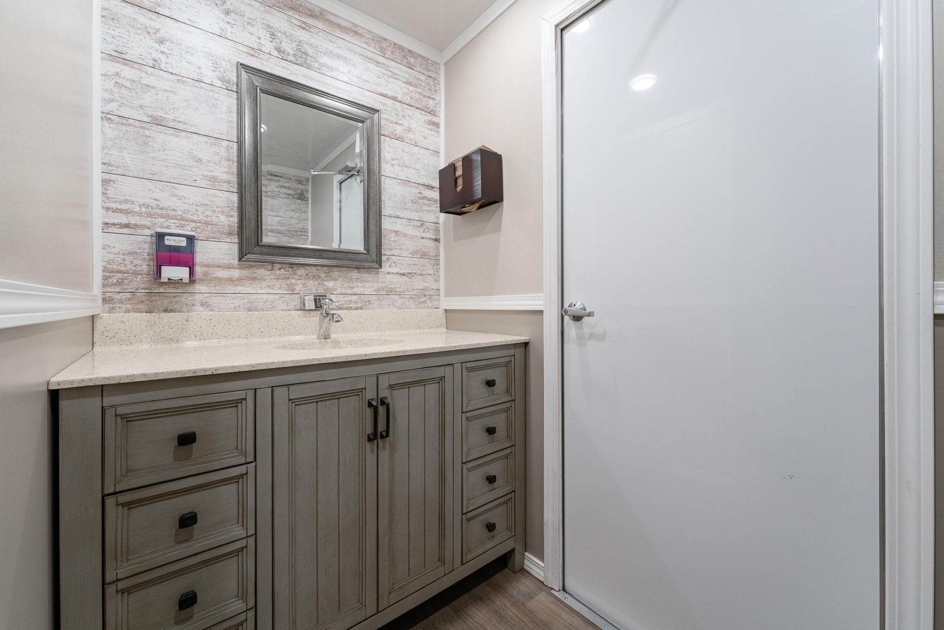 A bathroom with a sink, mirror, and drawers