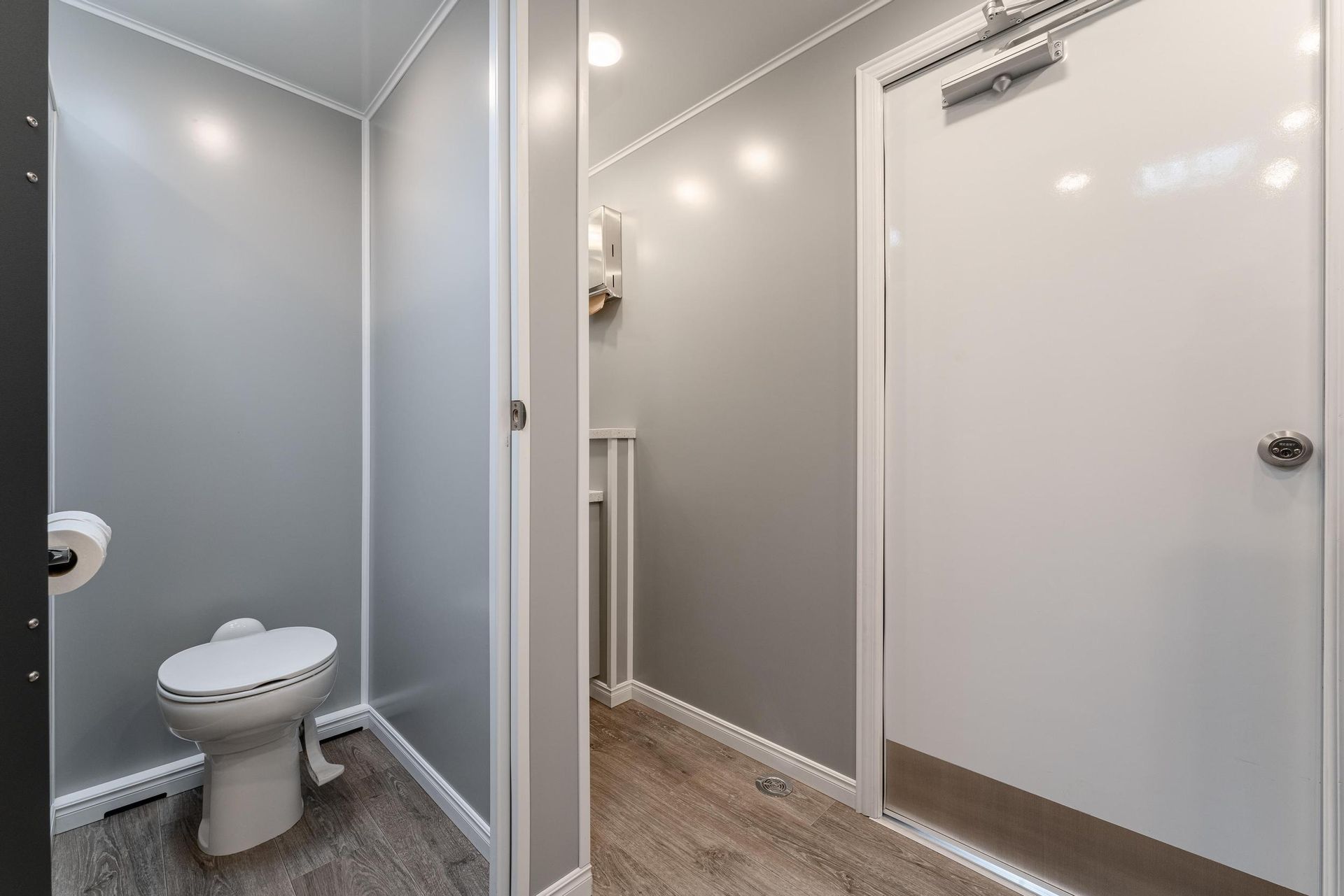 A bathroom with a toilet, sink, and door