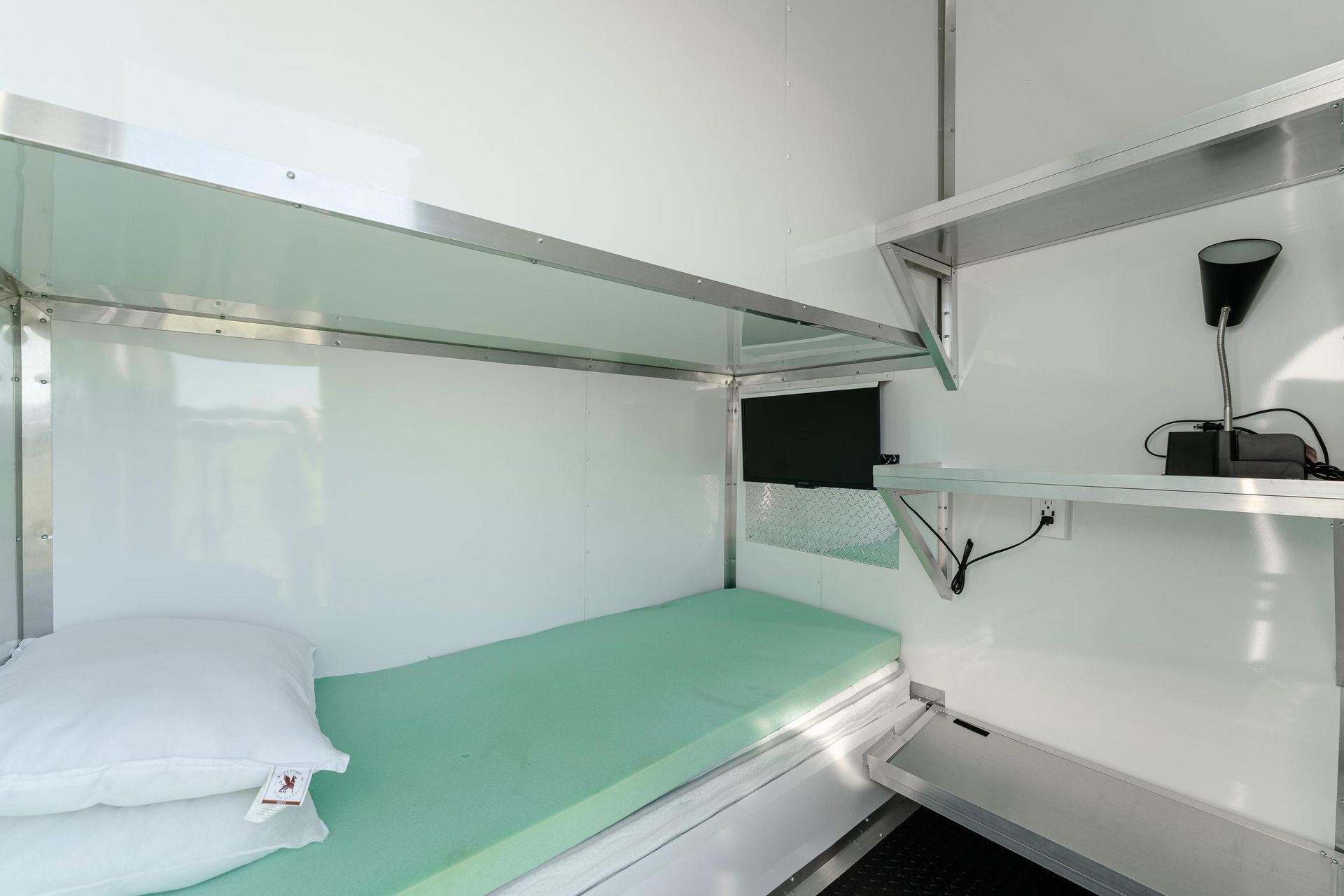 A bunk bed with a green mattress in a small room