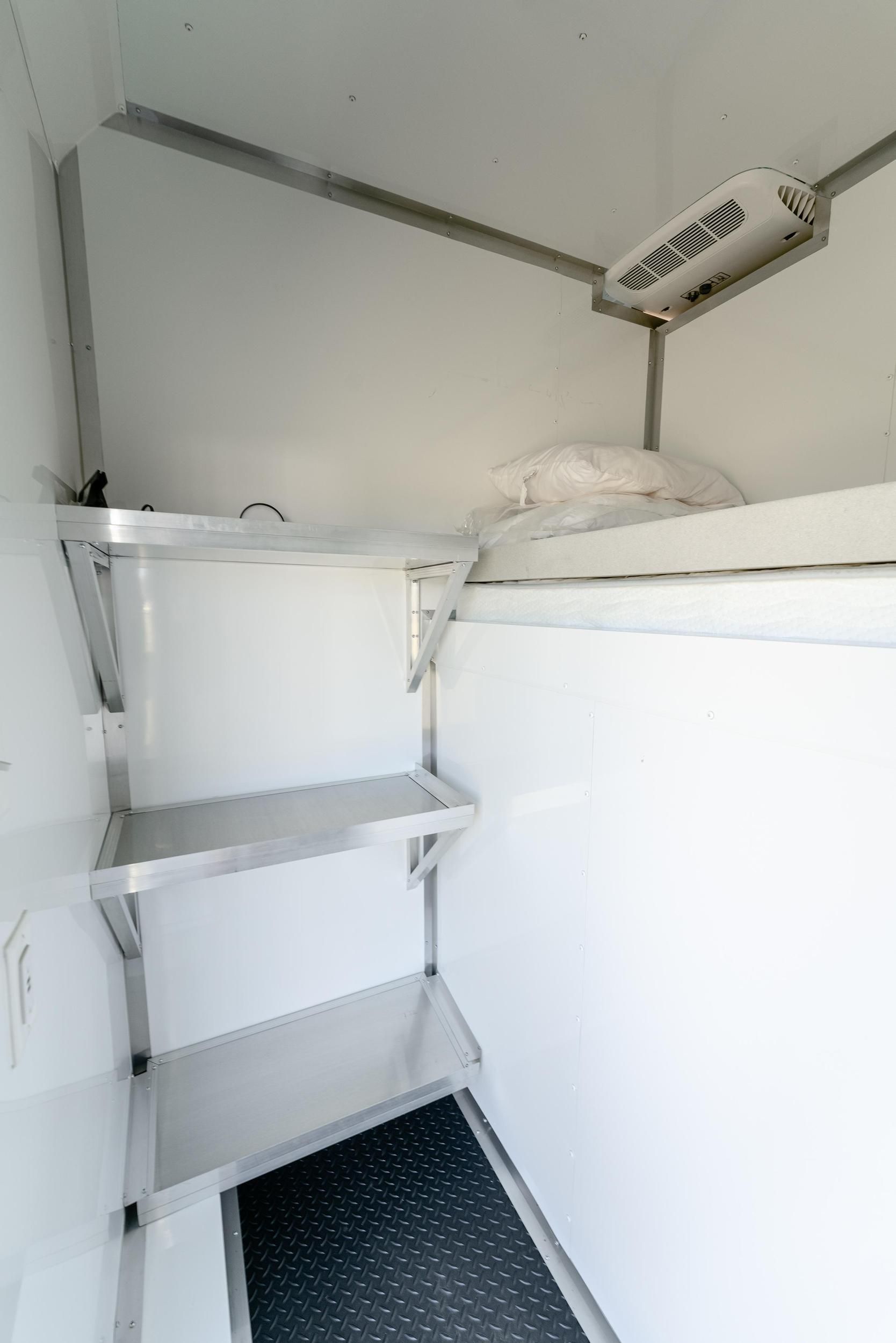 A white room with stainless steel shelves and a ceiling fan